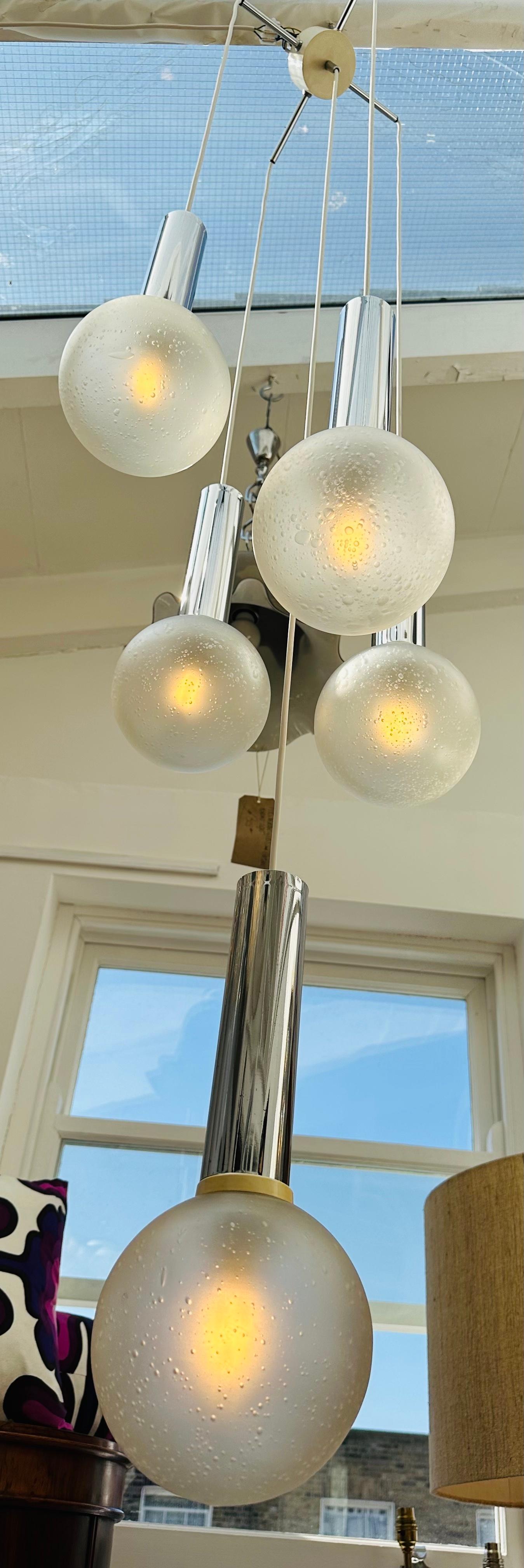 1970s Vintage German Sölken Leuchten chrome and bubbled frosted glass cascading hanging light. The light has 5 hanging shades suspended from a four star chrome and white-metal ceiling plate. The opaque frosted bubble glass shades hang from