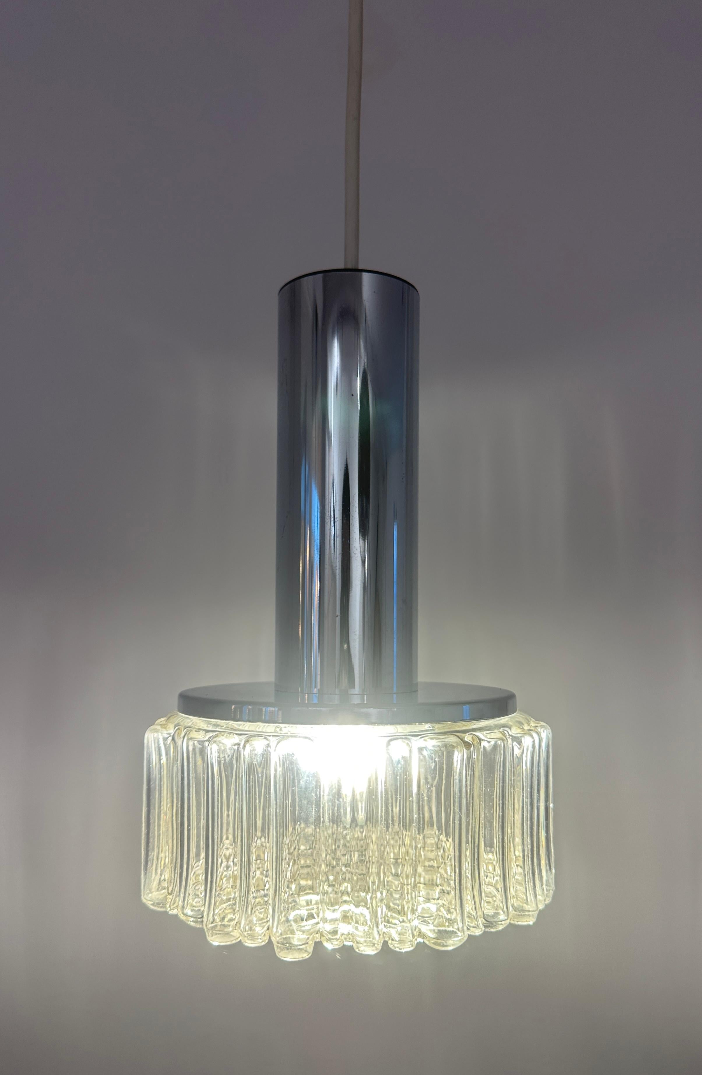 1970er Deutsche Staff Leuchten Hängelampen aus poliertem Chrom und klarem Glas.  Modell Nr. P105.  Entworfen von Rolf Krüger und hergestellt von Staff Leuchten.  

Die Glasschirme werden an der verchromten, röhrenförmigen Glühbirnenfassung
