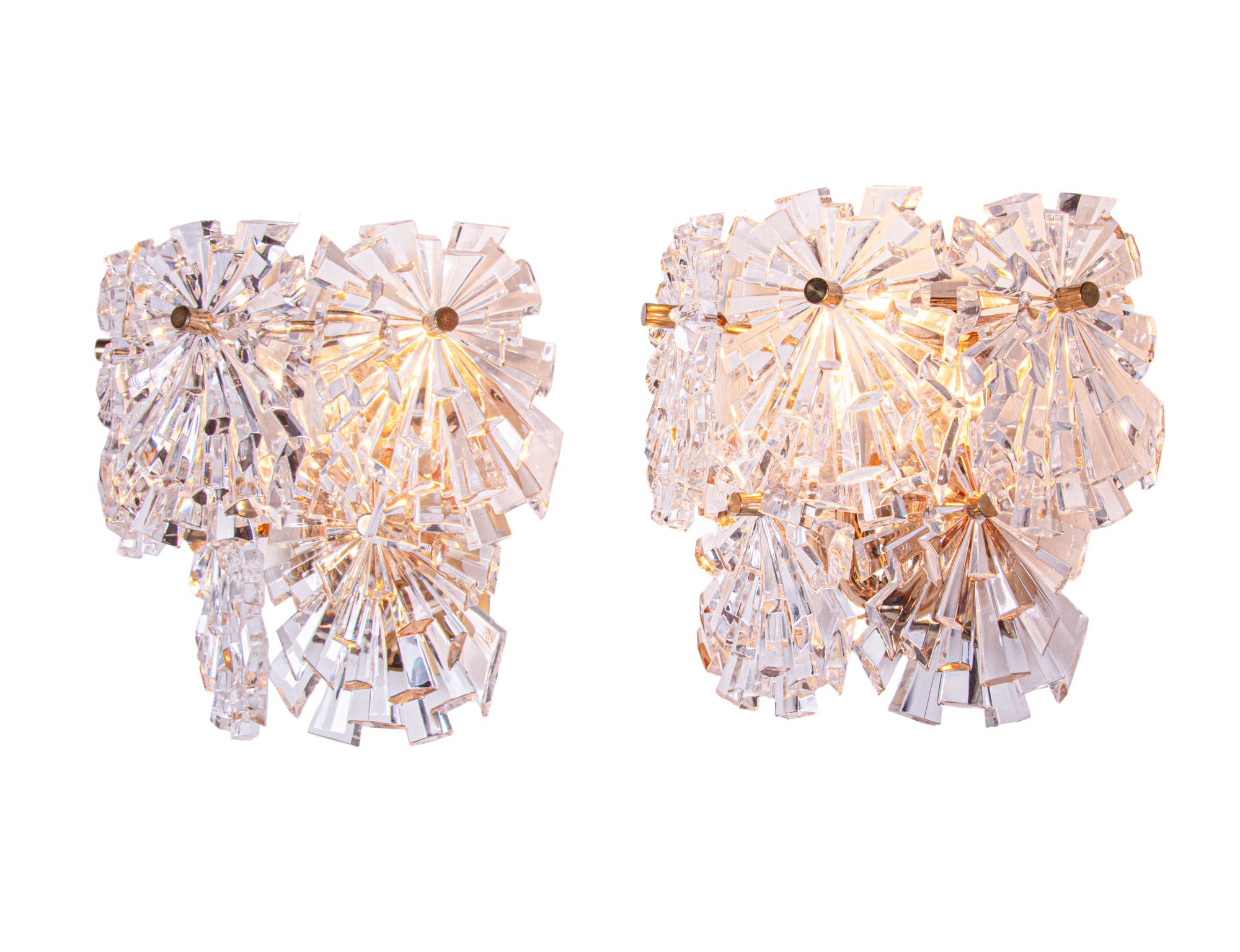 Elegant pair of starburst crystal glass wall sconces, each with ten faceted crystals mounted on gold-plated brass frame. Star-shaped crystal glass resembles flowers. With this light you make a clear statement in your interior design. Sconces