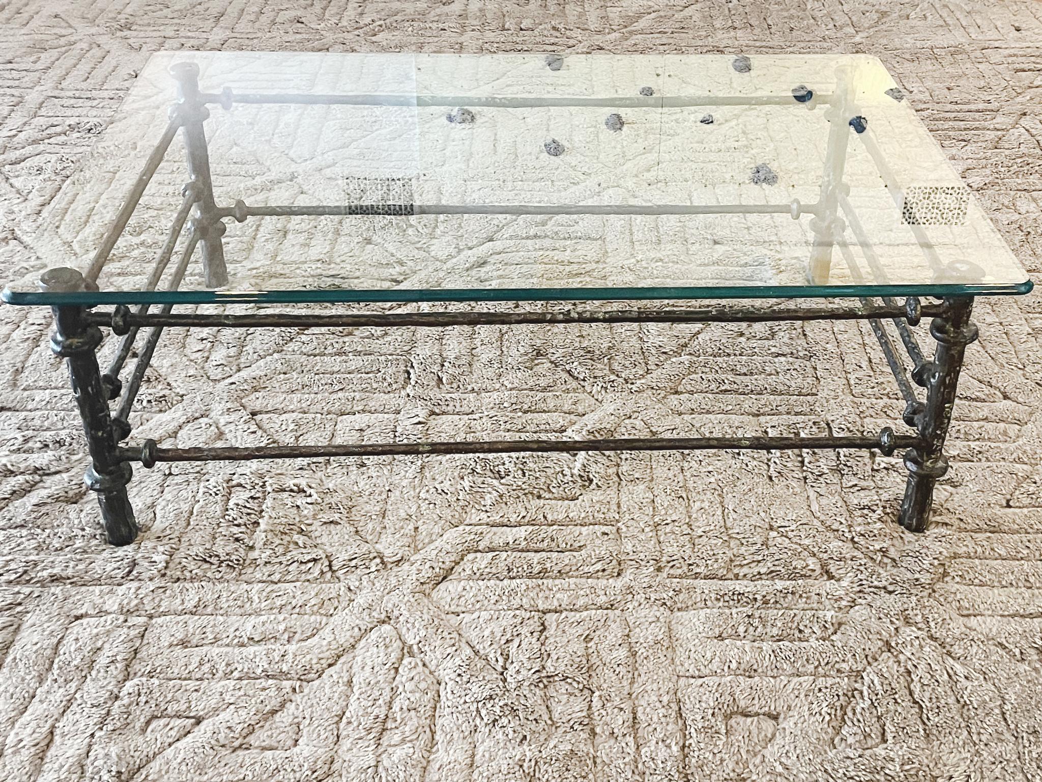 Biseauté Table basse de style Giacometti des années 1970 en métal patiné et verre en vente