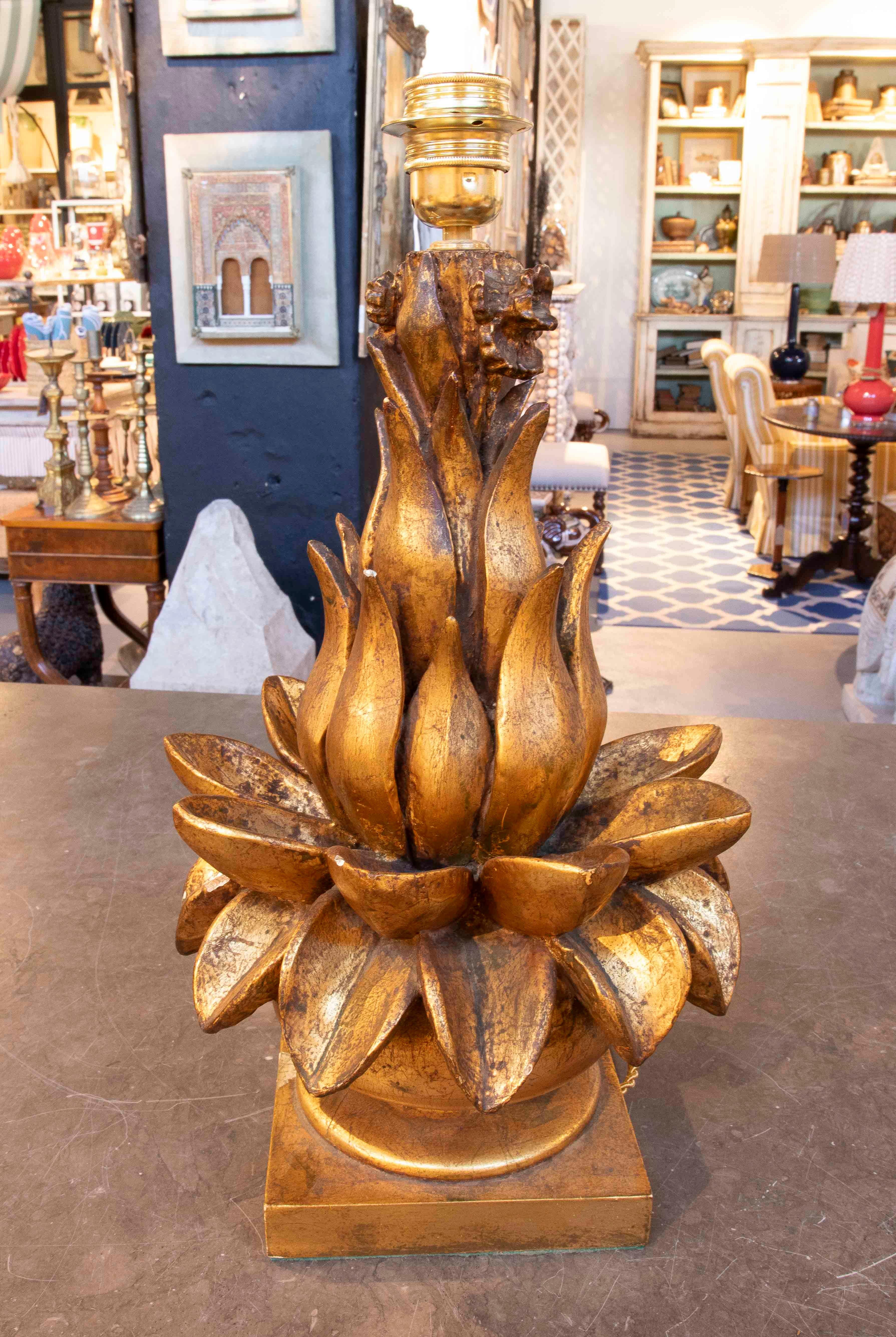 Lampe de table sophistiquée en bois du 20e siècle avec un design sculptural représentant une fleur stylisée avec des pétales qui se chevauchent. La pièce a été finement dorée à la feuille d'or, obtenant une finition chaude et élégante qui met en