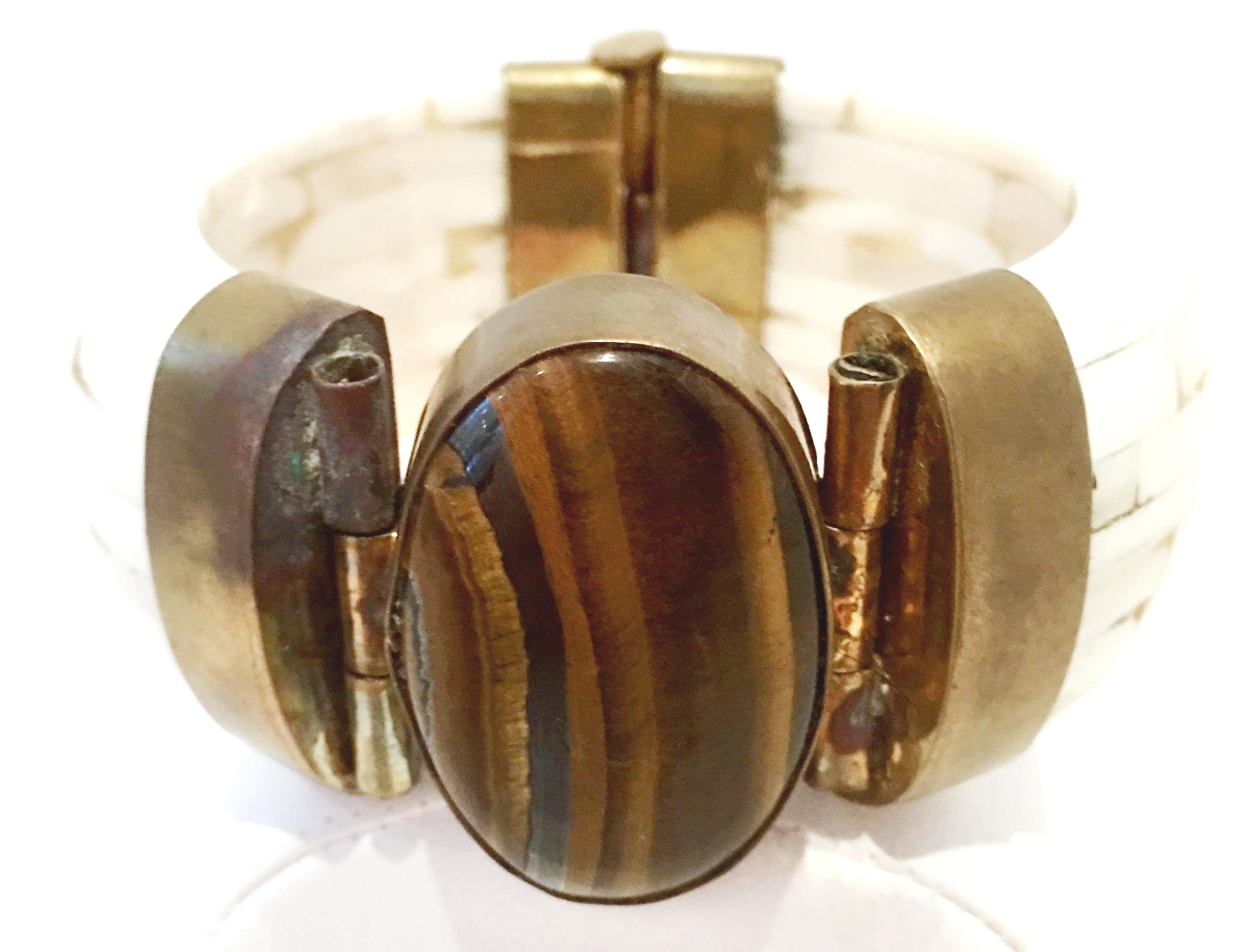 1970'S Gilt Brass, Carved Polished Bone & Monumental Polished Tigers Eye Hinged Bangle Bracelet.
Features a stunning cabochon set central polished tigers eye stone of approximately, 1.5
