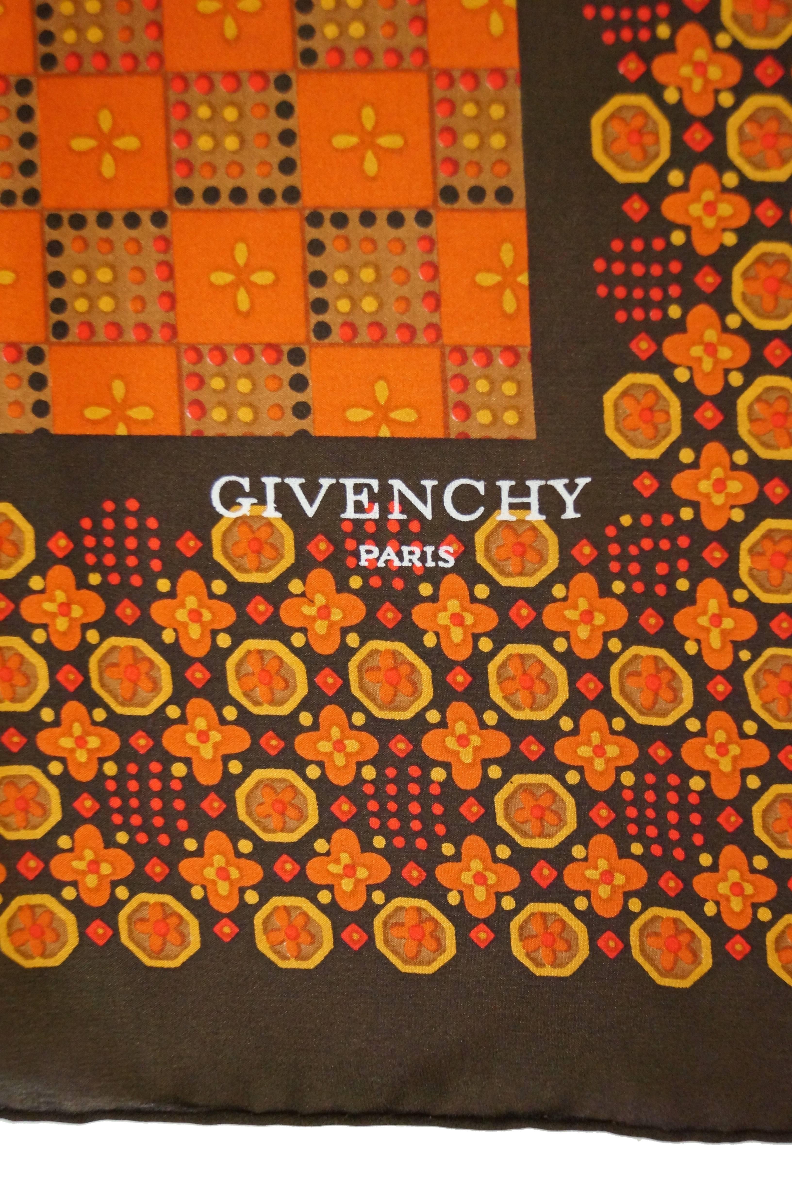 Beautiful large square silk scarf by Givenchy. The scarf has a mostly orange center with a wide brown - orange border. The scarf features geometric patterns incorporating floral elements. 