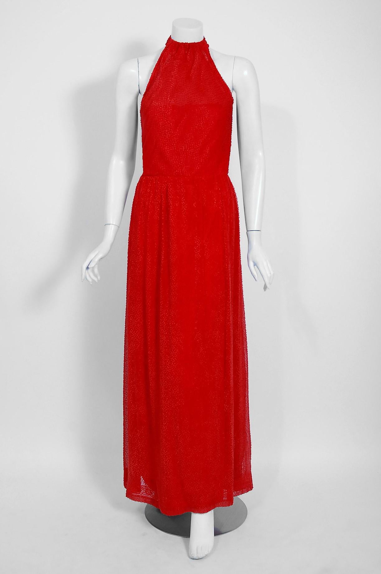 Givenchy, the name itself evokes glamour, refined elegance, simplicity and style. Givenchy's trademark of flowing lines and luxurious fabrics make his work easily recognizable. This gorgeous ruby-red goddess gown, dating back to the mid 1970's, is a