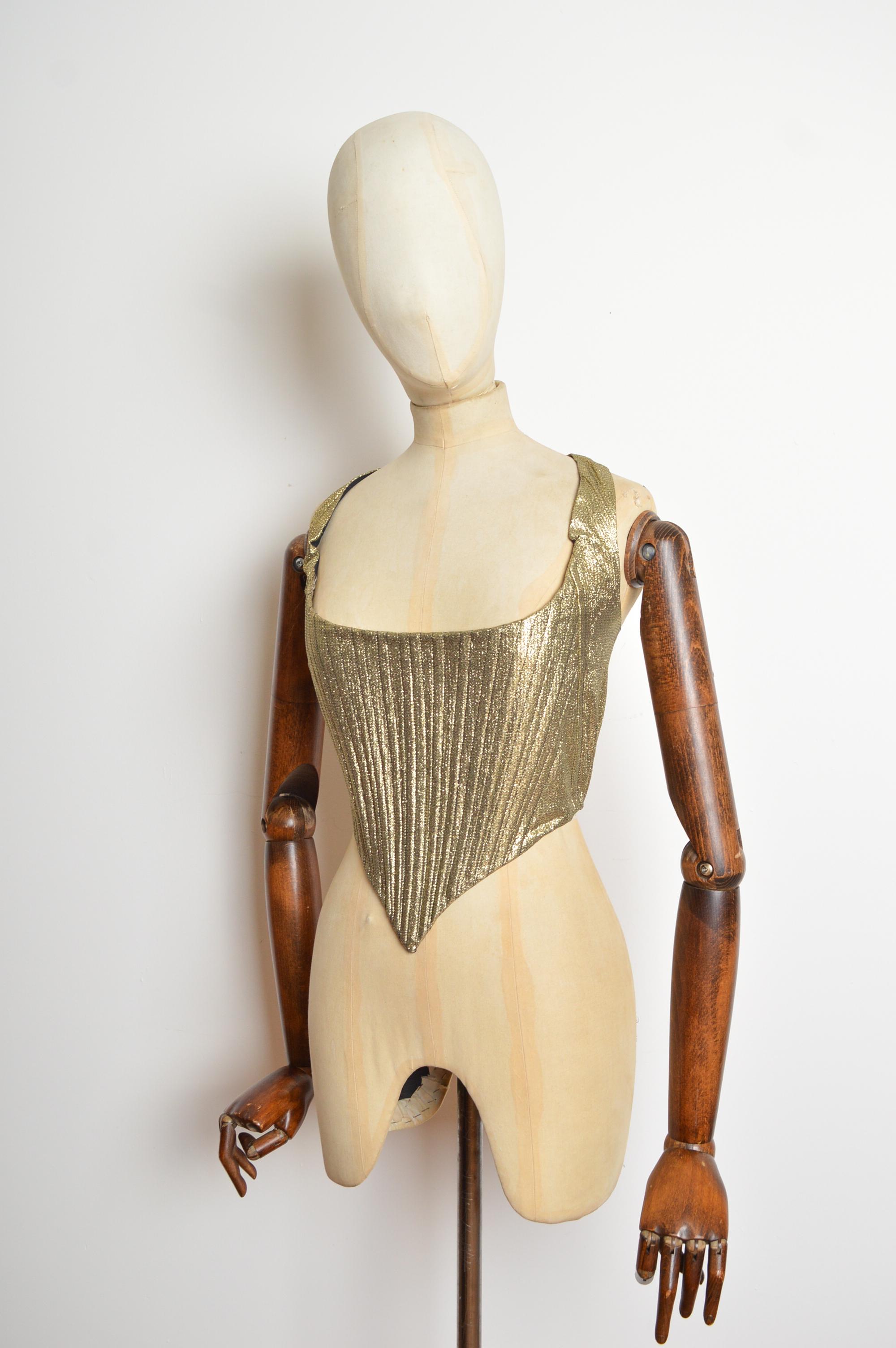 1970er Jahre Glam Rock Korsett aus Goldlamé mit spitzen Knochen, mit Rundhalsausschnitt, spitzer Taille (mit elastischem Saum) und Hufschmied-Hakenverschluss. 
Empfohlene Größe; UK 6 
Die Maße sind in Zoll ('') angegeben.
Grube zu Grube;