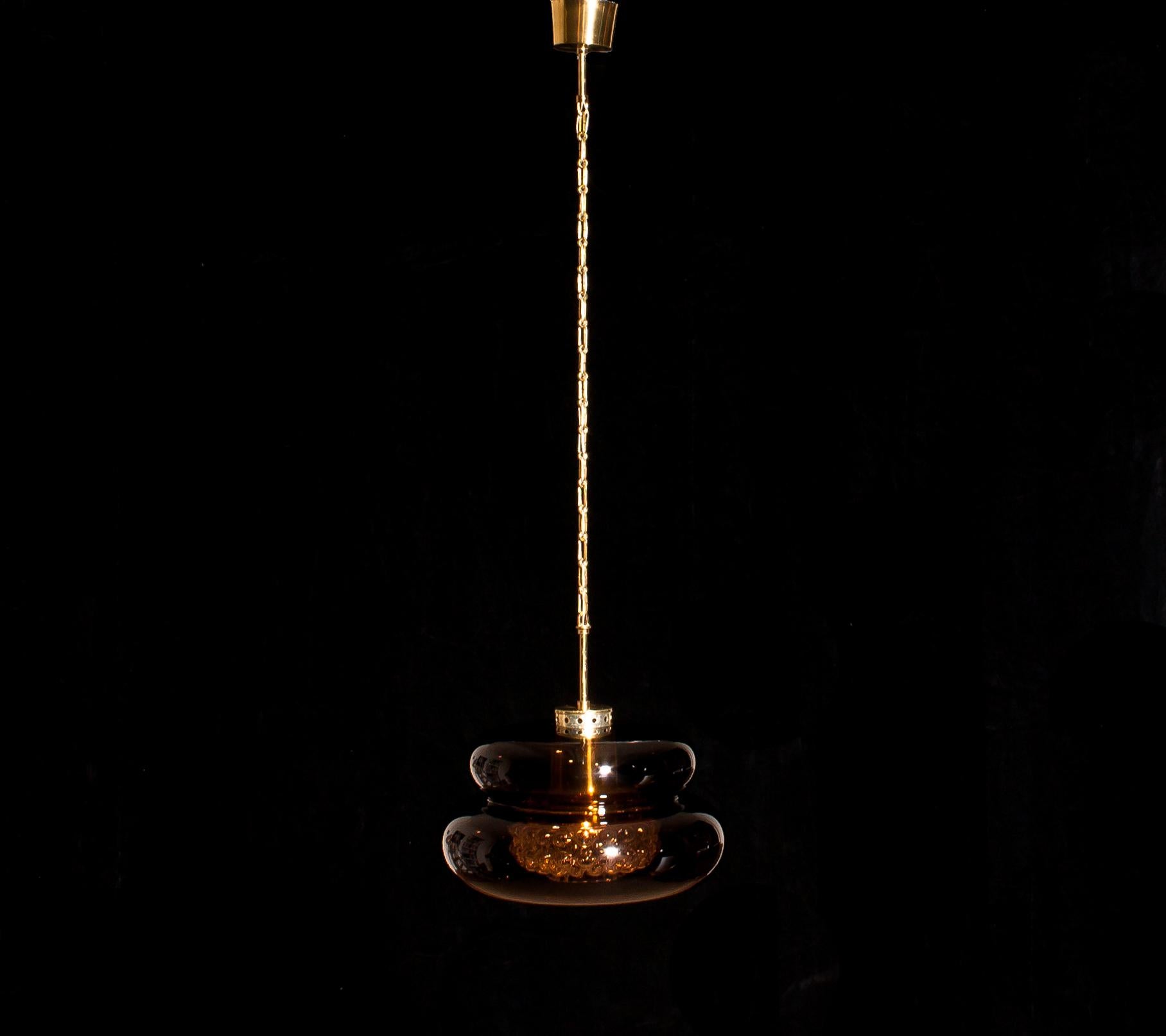 Beautiful pendant 'Bubblan' designed by Carl Fagerlund for Orrefors Sweden.
This lamp has a shade of brown smoked glass on the outside with a clear bubbled glass cylinder on the inside and it has brass details.
It is in wonderful condition,
circa
