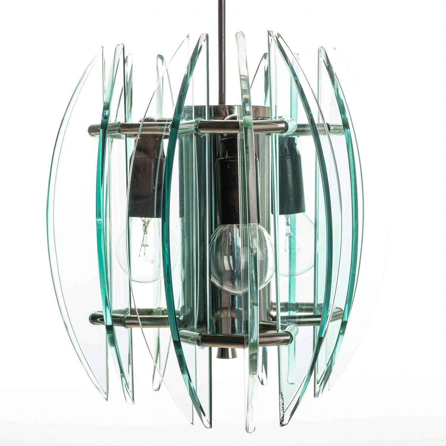 This stylish lamp is made with arc-shaped glass panels surrounding three E14 sized bulbs. The alternating thickness of the glass gives an extra edge to the design. Please note that some of the glass pieces have small chips around the edges, only