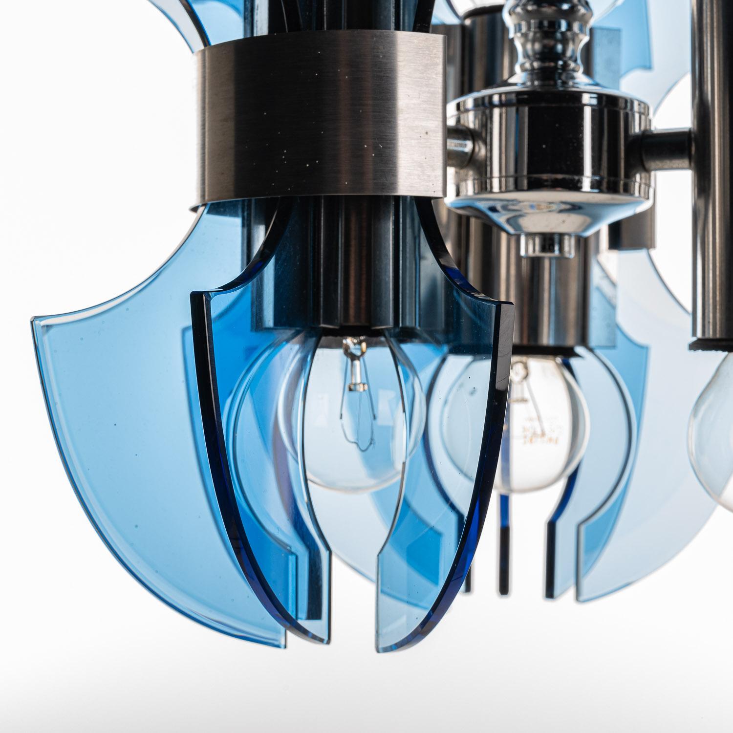 This striking piece of '70s design is sure to catch the eye with its Retro charm. Distinctive blue-tinted glass plates surround the six E14-sized bulbs, held in place by chrome collars. In turn, these connect to a chrome body housing the connecting