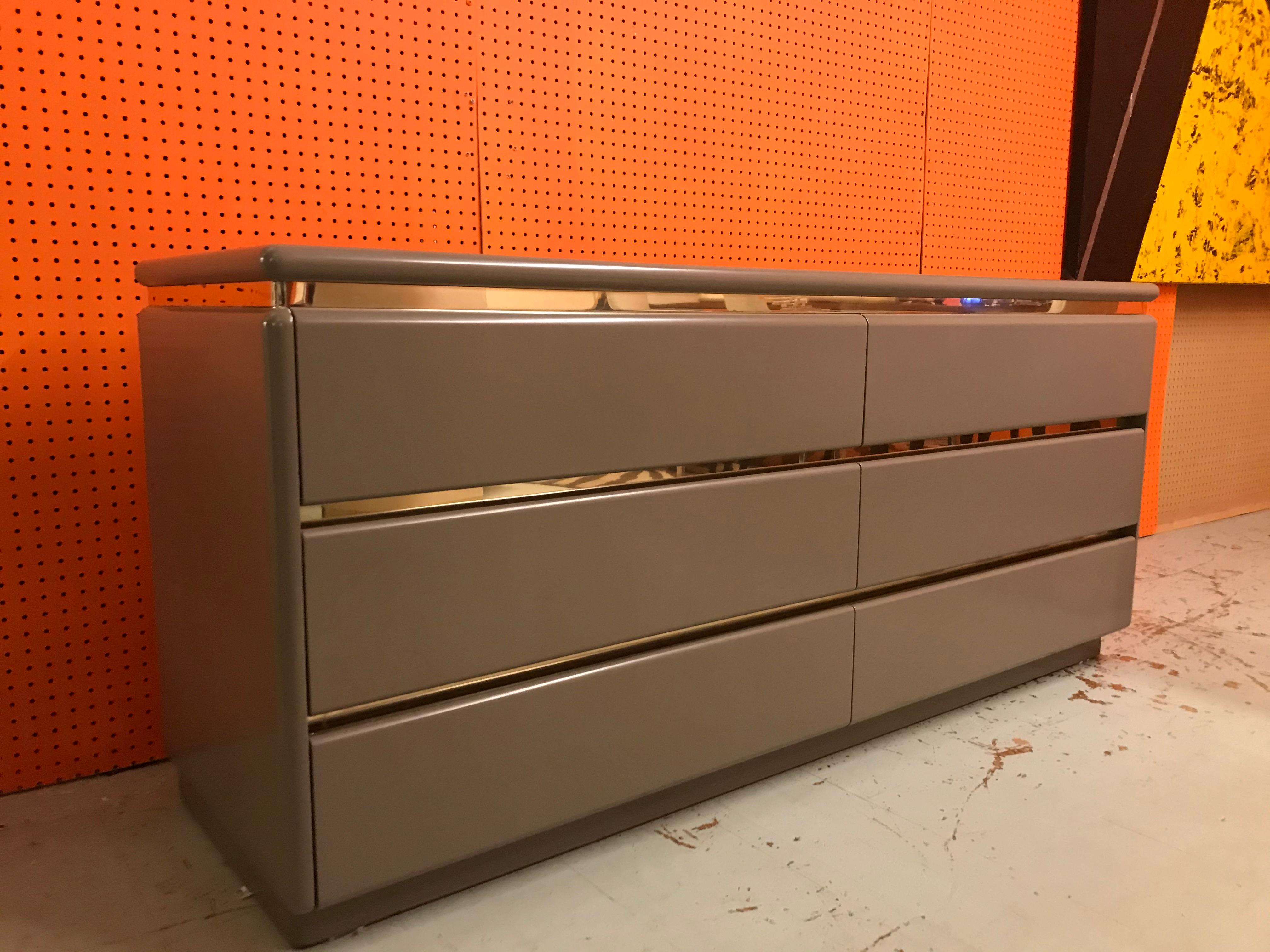 Chic dresser made in the 1970s. It features 6 large drawers separated by brass.
   