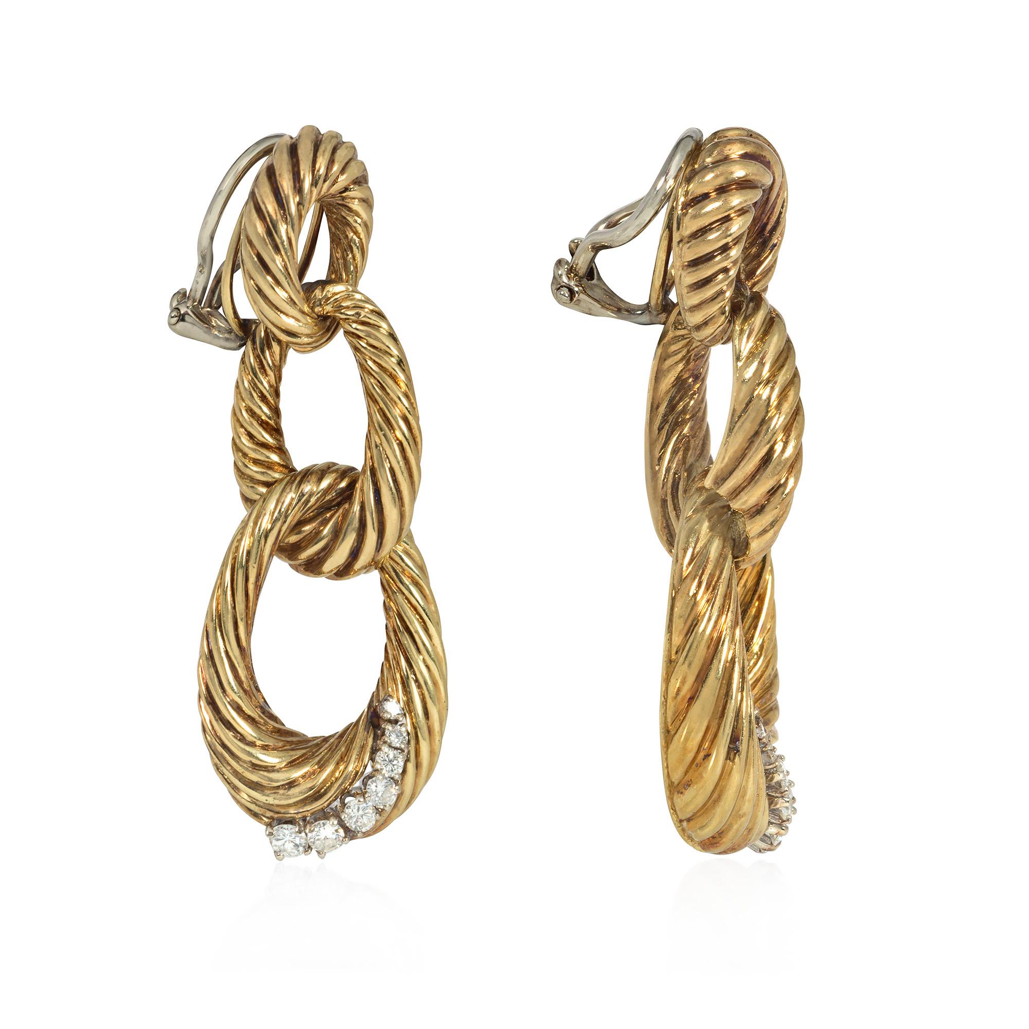 A pair of gold and diamond pendant earrings comprised of three graduated interlocking ribbed gold rings, the bottom ring accented with a curved diamond stripe, in 18k.  Atw 0.67 ct.