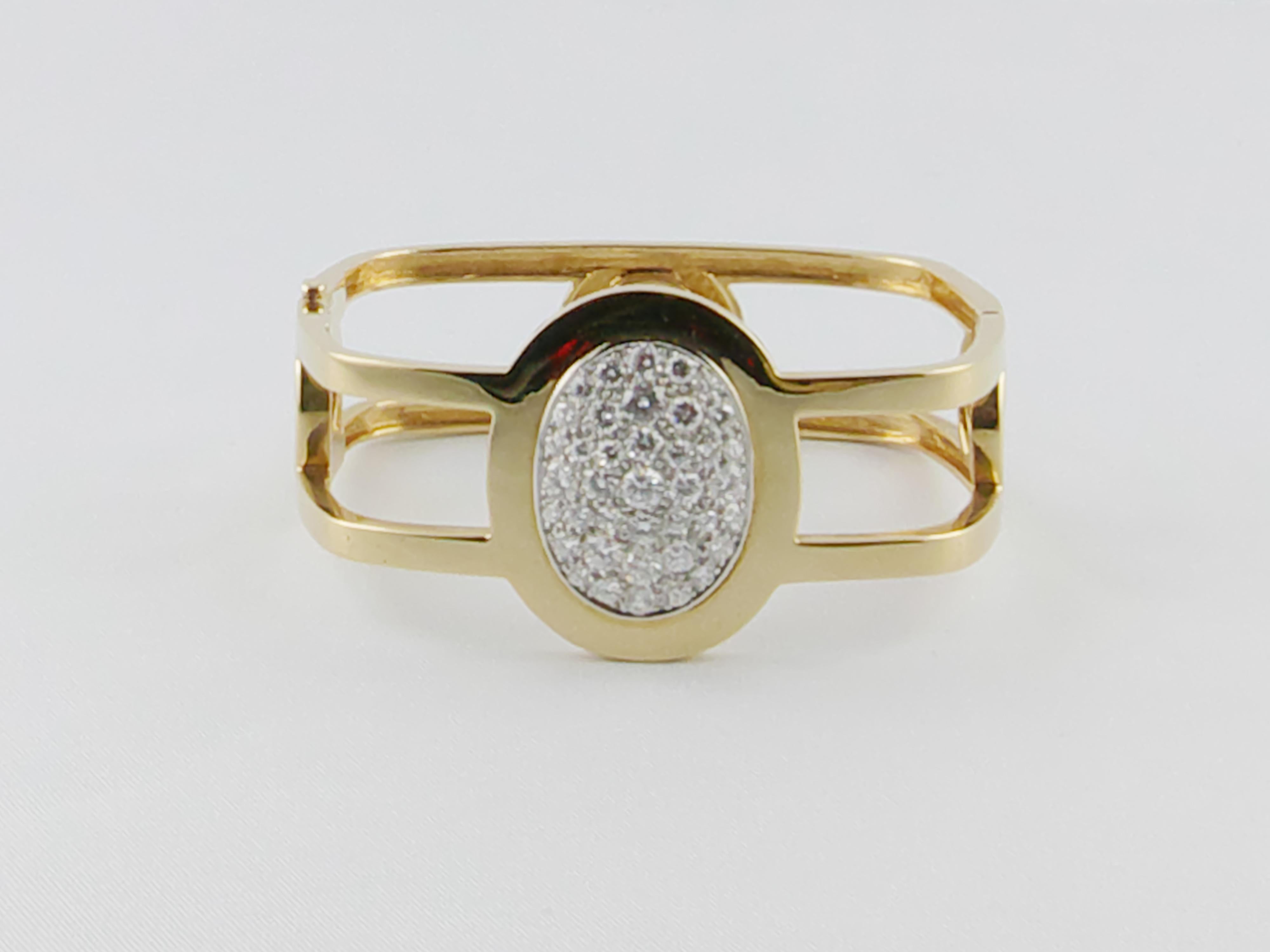 A stunning and sleek 1970s  18K yellow gold bangle bracelet set with diamonds. The shape is a soft square with approx 1.8 cts diamond pavé oval shaped element in the centre. The bold and geometric design make it chic, fashionable and extremely