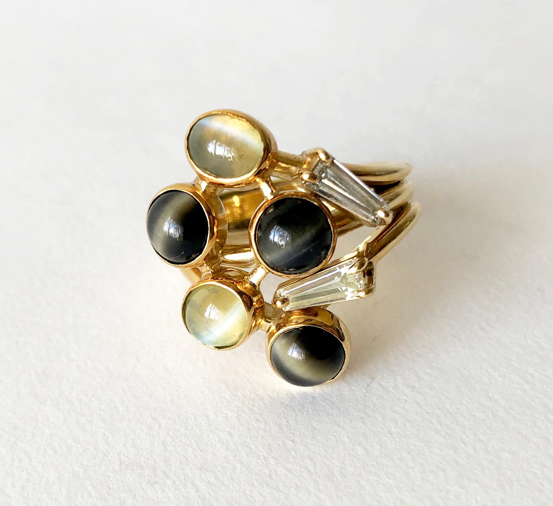 Heavy, custom made cocktail ring comprised of two long, tapered baguette diamonds intertwined with five natural cats eye gemstone cabochons. Ring is a finger size 11 and does look great on the middle or forefinger.  Unsigned.  21.4 grams and in very