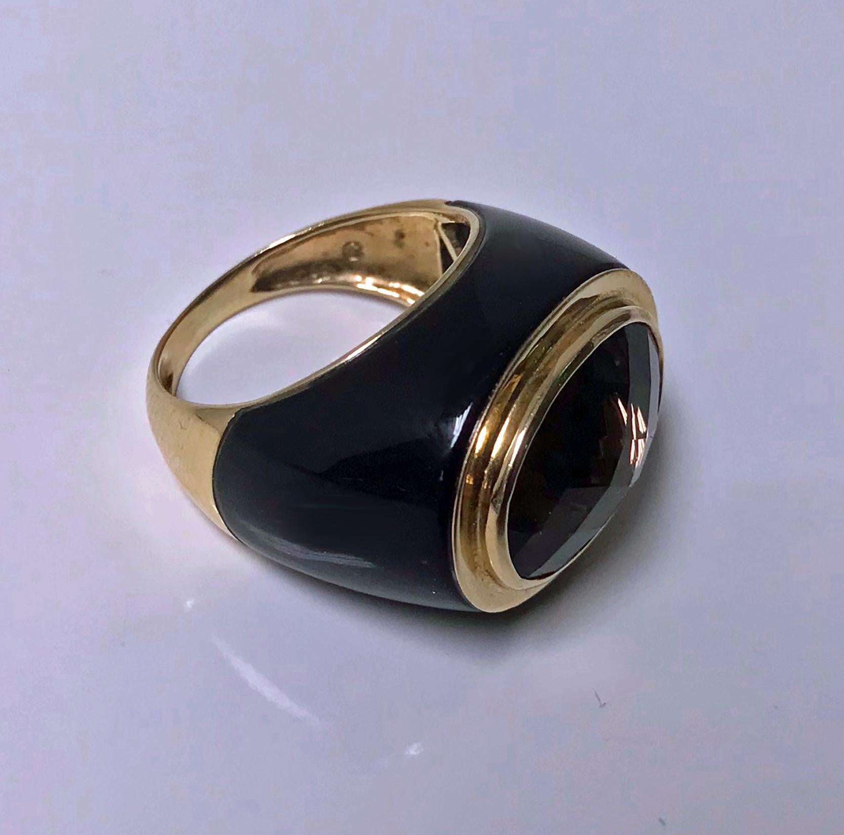 Gold Enamel Topaz Ring. The Ring 14K gold bezel set with a facetted smoky topaz, gauging approximately 15 x 12 mm, black enamel surround mount and shoulders, tapered gold shank, stamped 14K. Ring Size: 7. Item Weight: 9.70 grams. Ring measures