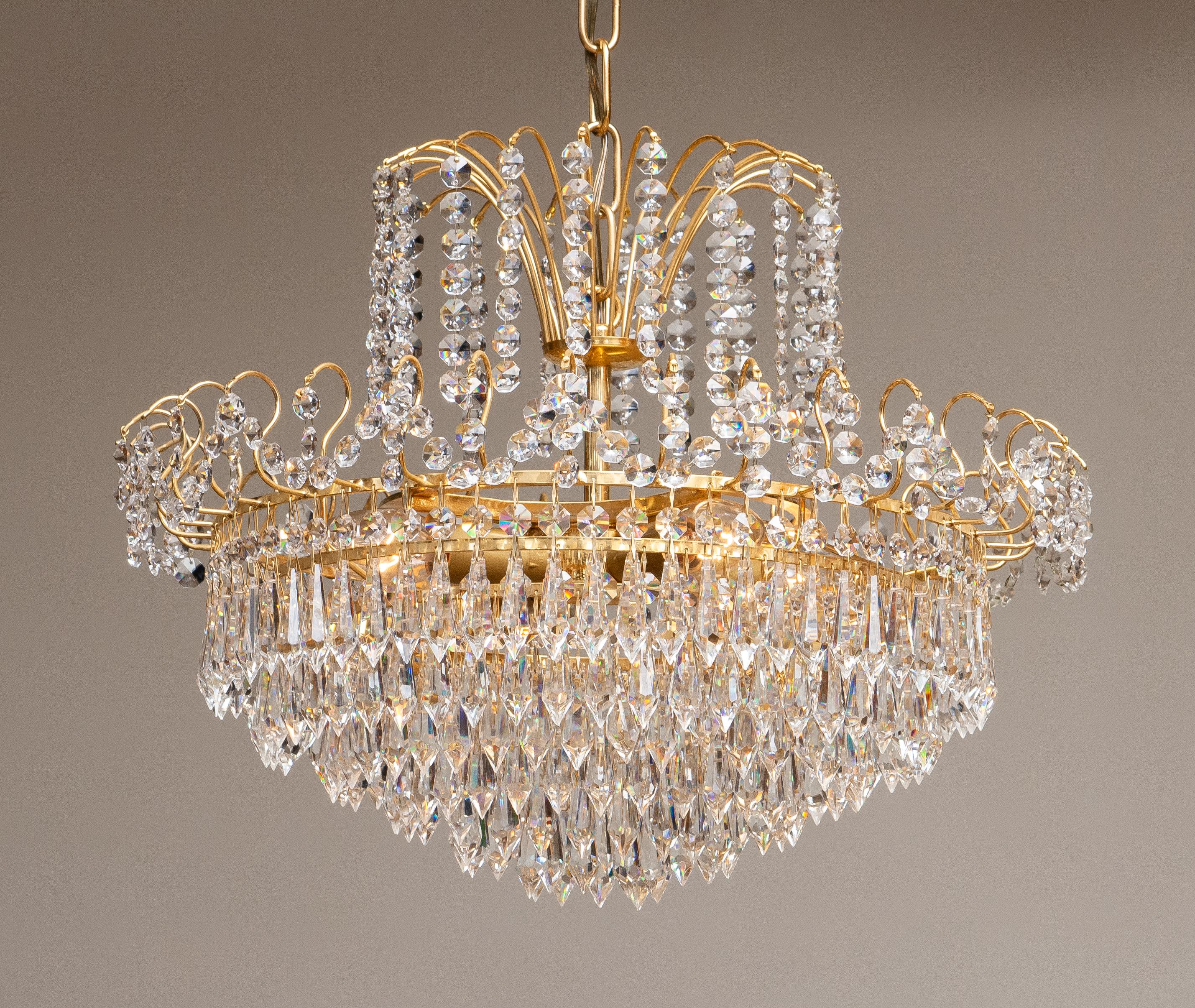 Beautiful gold-plated chandelier attributed to Rejmyre Armaturfabrik Rejmyre, Sweden, 1970s.
The chandelier is build up out of six rings and two crowns filled with faceted crystal, total diameter of the fixture is 44cm or 17