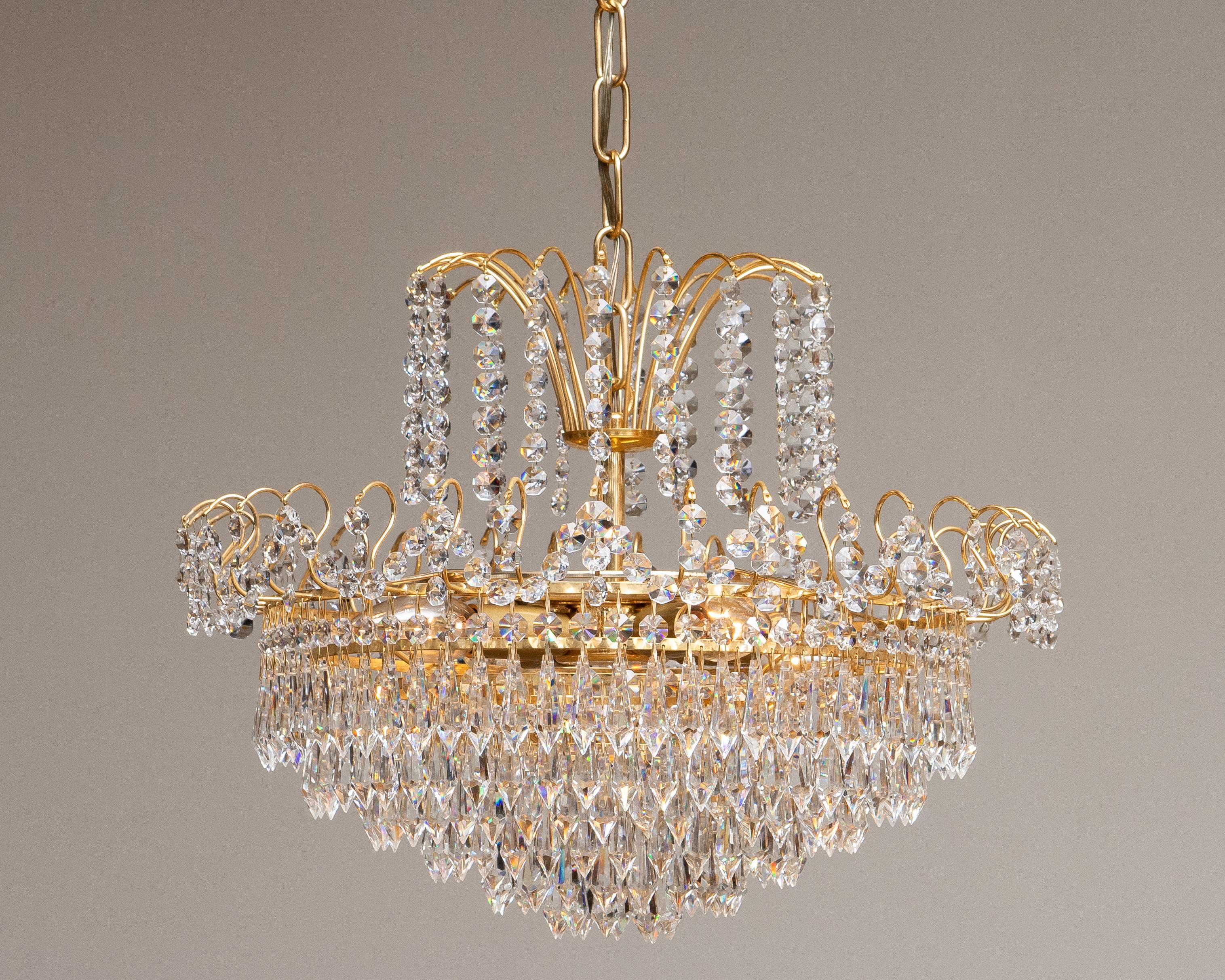 Bellissimo lampadario placcato oro Svezia, anni '70.
Il lampadario è composto da sei anelli e due corone di cristallo sfaccettato; il diametro totale dell'apparecchio è di 44 cm.
L'apparecchio è composto da quattro raccordi a vite di dimensioni