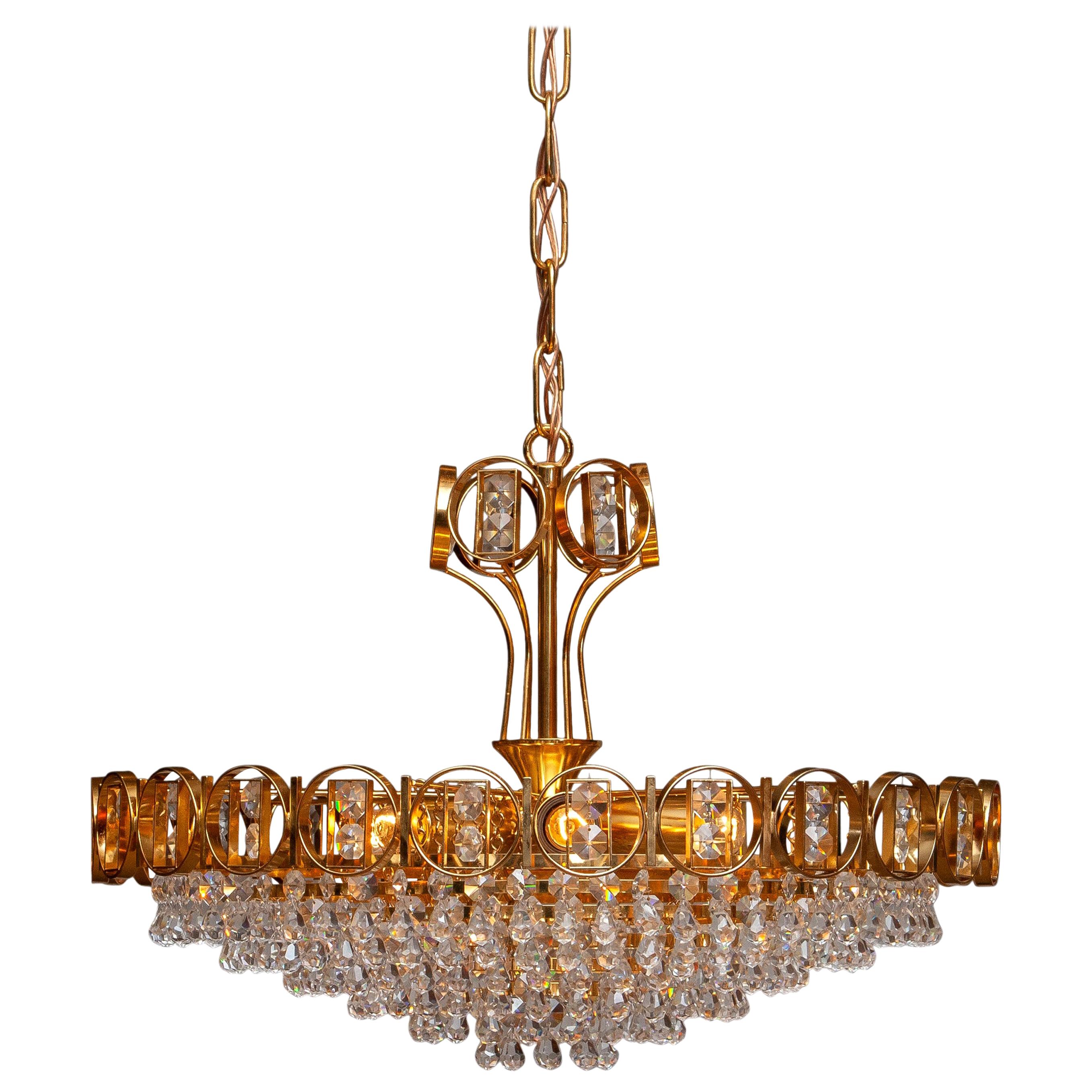 Beautiful brass gilded chandelier filed with faceted crystals made by Palwa, Germany, 1970.
This chandelier consists out of a gold-plated crown with inside six gold plaited rings filed with crystals and on top also a smaller gold plaited