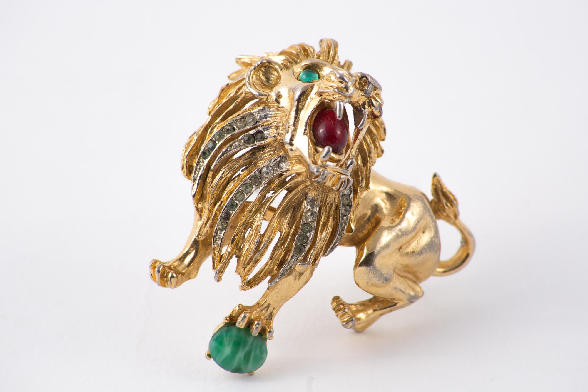 1970s lion animal gold tone brooch featuring green strass for eyes, beads and strass, a back safety brooch pin.
Length: 2.3in. (6cm)
Width: 2in. (5.5cm)
Please note this item is in good condition with minor wear consistent with age and use. (please