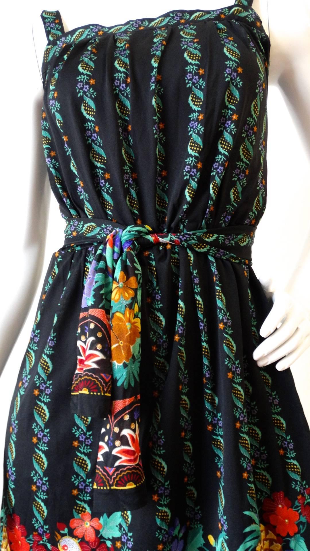 It's not Gucci it's Gottex! Rock the spirit of the 1970s in our incredible Gottex floral dress! Black sheer stretch fabric with striped multicolor floral print. Colorful birds hidden within the floral pattern around the skirt. Cinches in perfectly