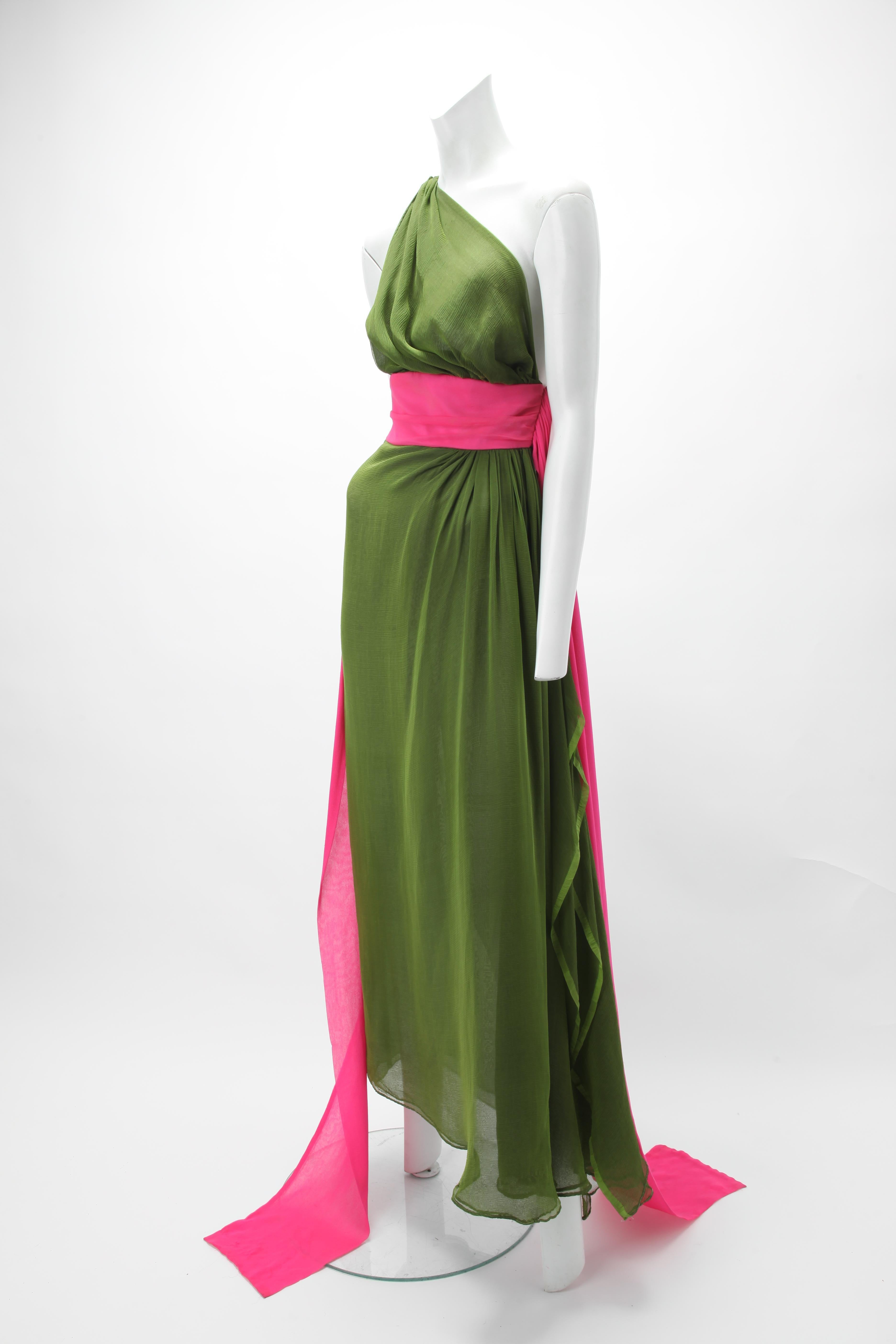 1970s One Shoulder Green Silk Chiffon Dress; Draped one shoulder bodice; Pink silk chiffon waistband with cascading floor length panels. Floor length skirt with high slit at side. Fastens with self fabric covered buttons and rouleau loops.