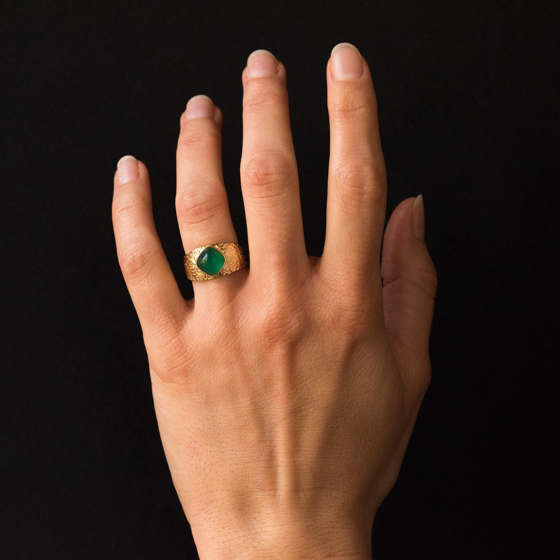 Ring in 18 karat yellow gold.
This retro ring is adorned on the top with a green cabochon agate in a closed setting, surrounded by a carving on the top of the ring.
Agate total weight: about 1.85 carat.
Height: 10.2 mm, width: 9.5 mm, thickness: