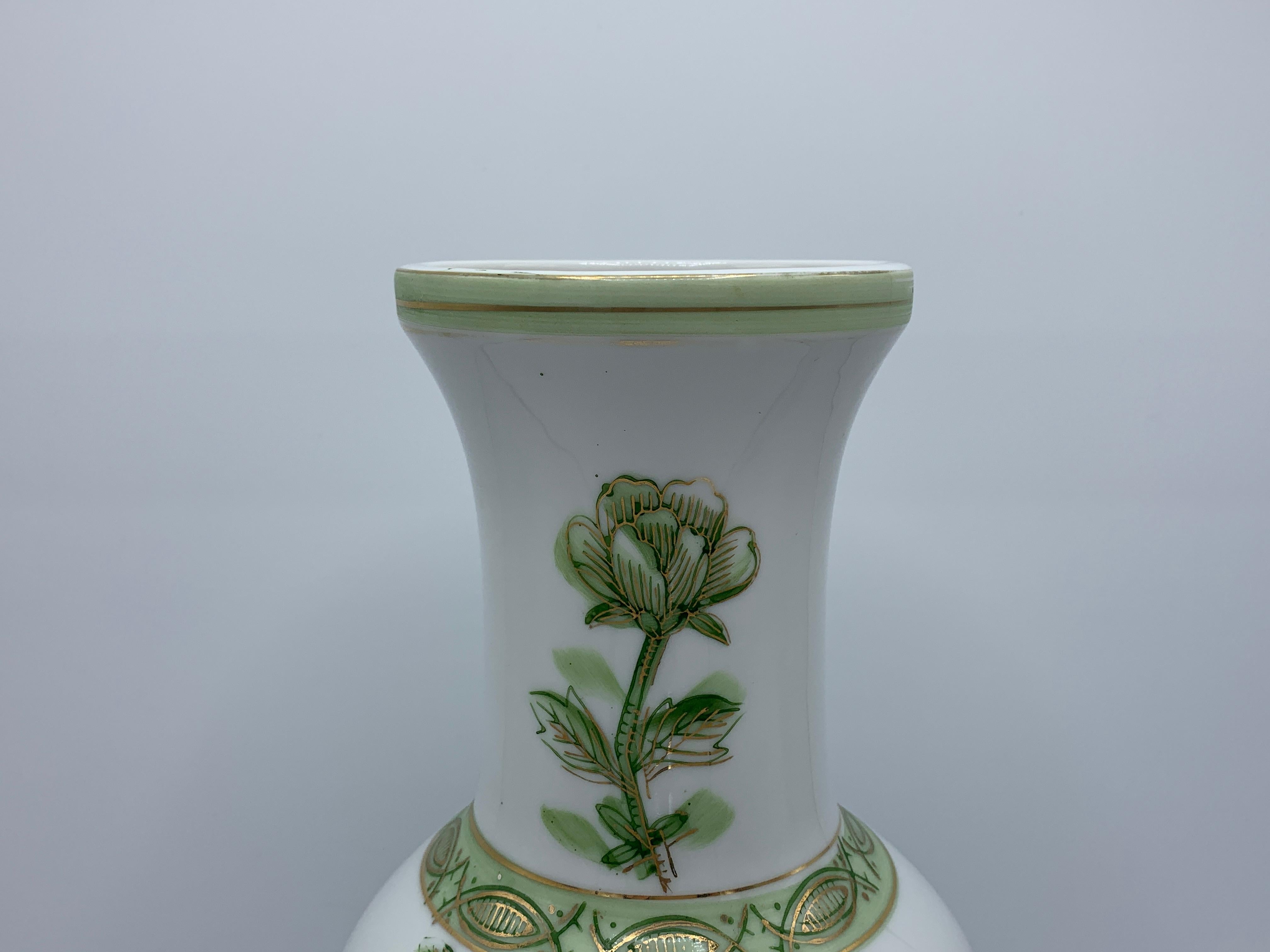 Listed is a gorgeous, traditional 1970s Chinoiserie green and white porcelain vase with an all over peony motif, in the style of Gold Imari.
