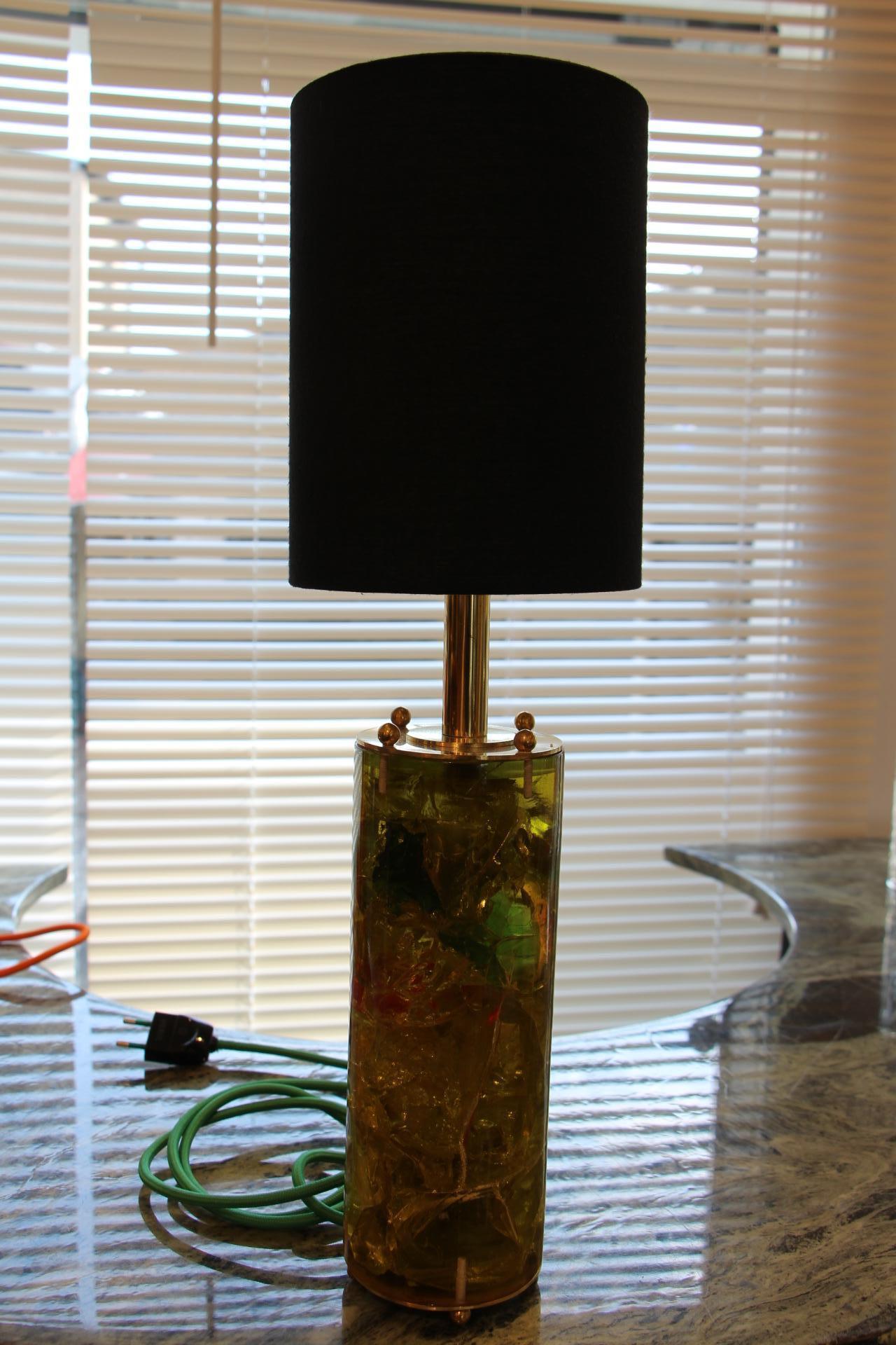 This cylindrical lamps is very poetic with all its small captivated fragments. Its color ranges from yellow to green with dark green and red inclusions. It always seems to be in movement.
Its total height including its shade is 51 cm, the height of