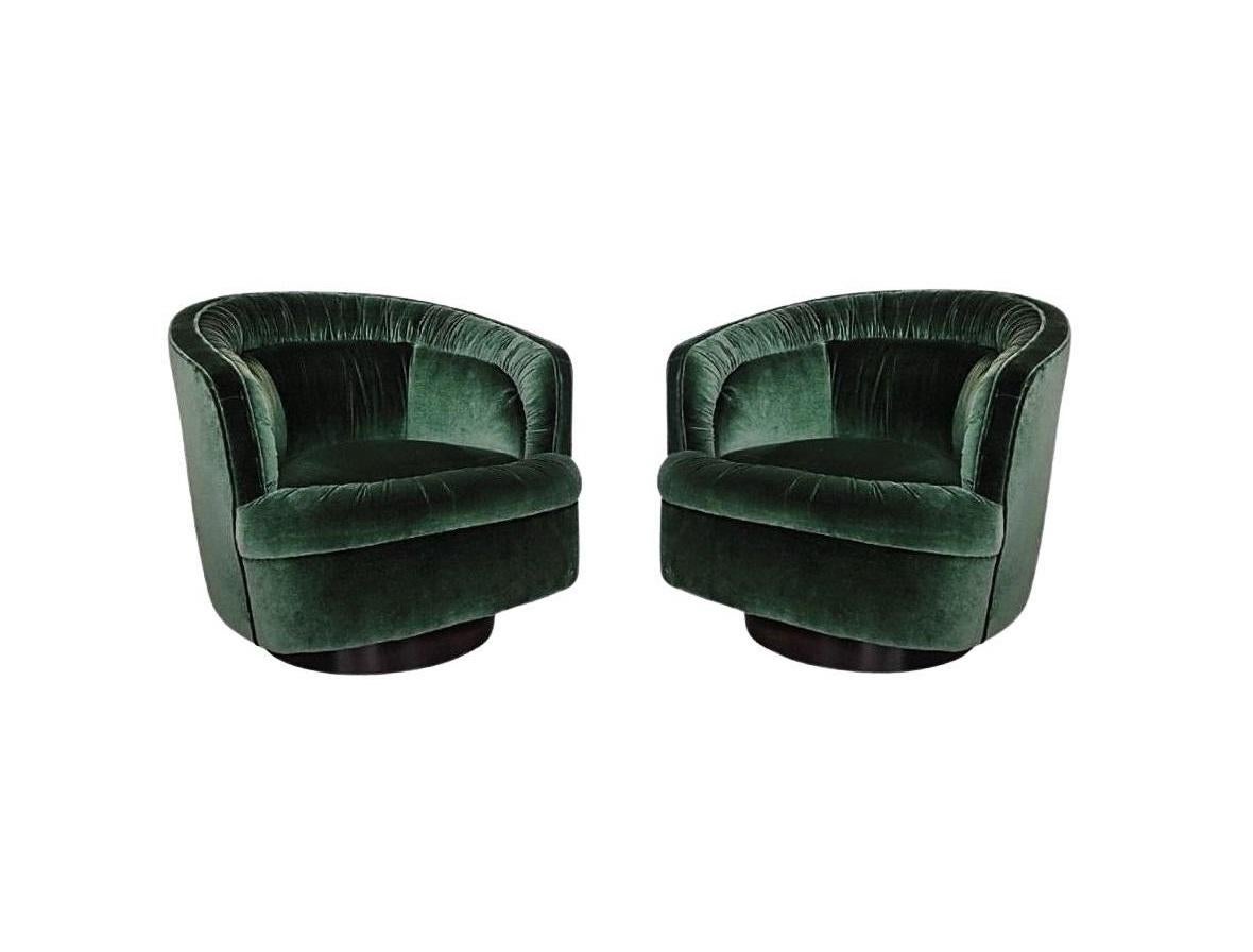 Stunning pair of swivel chairs in the style of Milo Baughman. An elegant take on an iconic shape, its smooth silhouette is accentuated by a hand-ruched tufting seat back, adding visual interest to the clean lined piece. Resting on wooden plinth