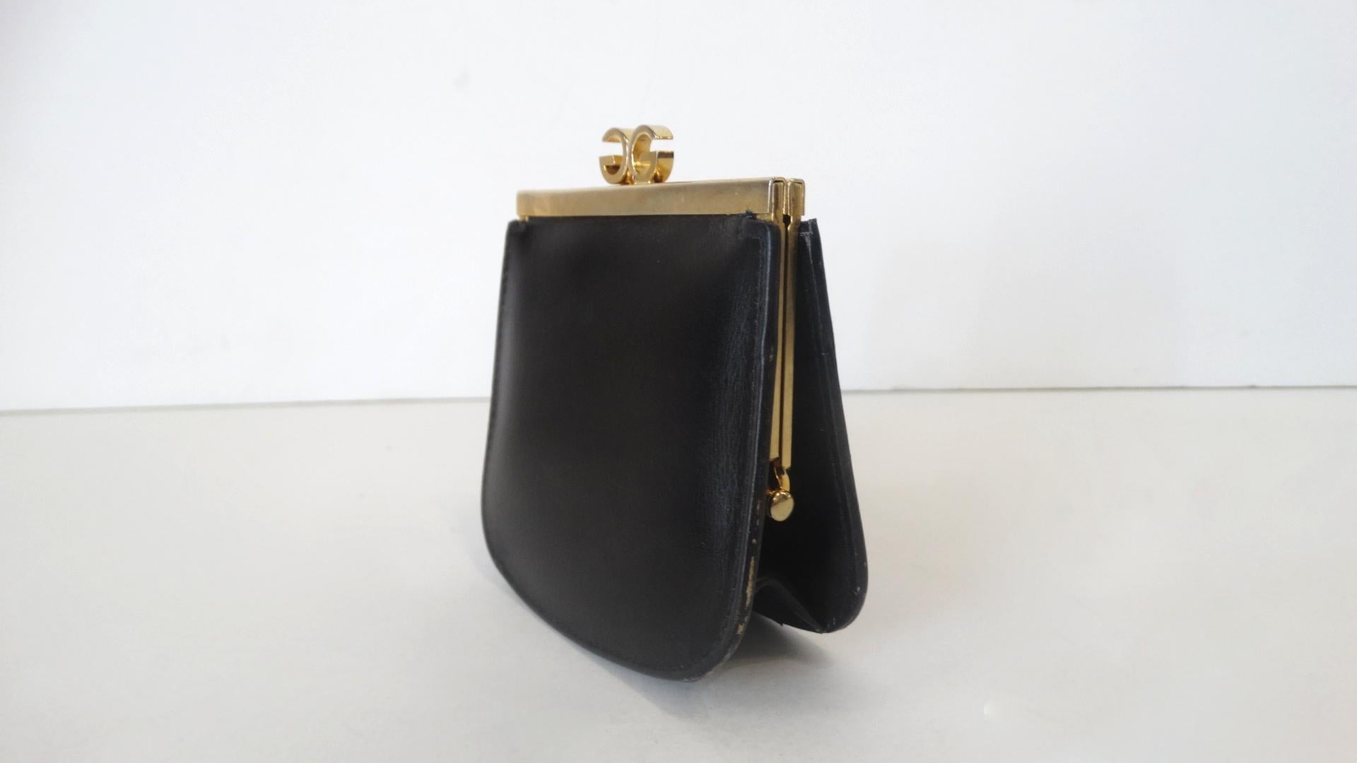 Always Carry Some Vintage With You! Circa 1970s, this Gucci coin purse is made of black smooth leather and features gold plated hardware. The signature GG is included on the top for a clasp closure. Interior is black leather and signed Gucci Made in