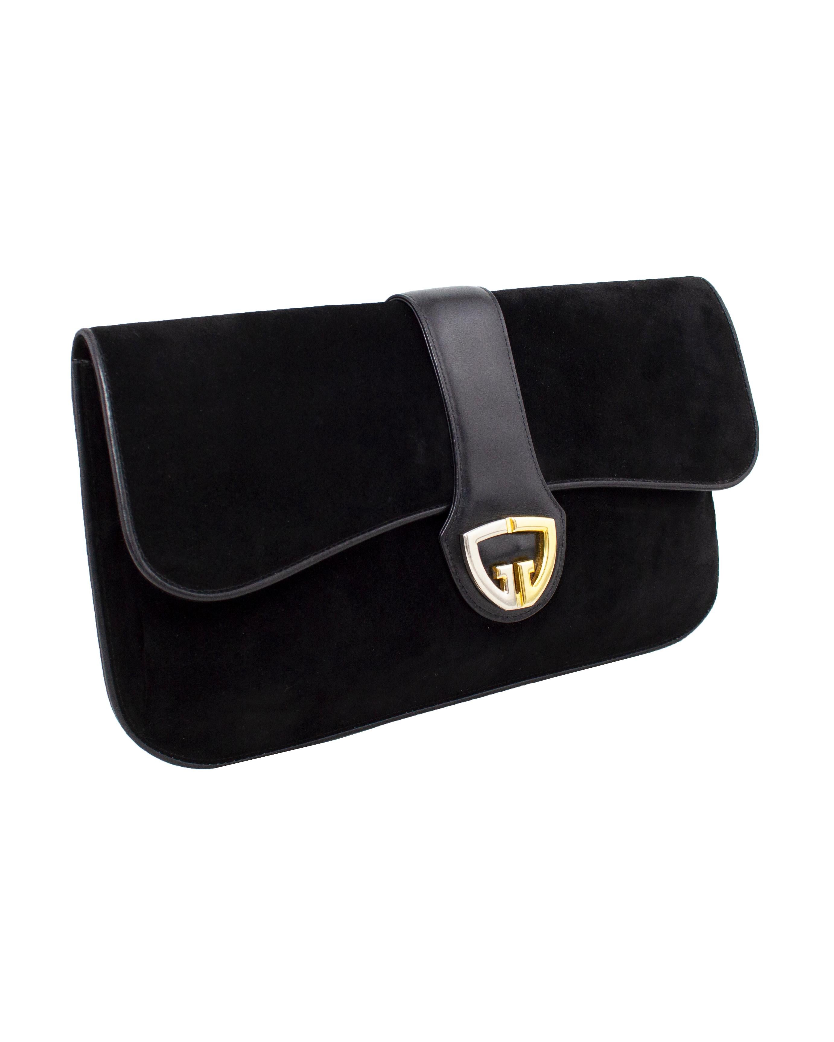 Fabulous Gucci large black suede and leather clutch from the 1970s. Envelope style with a flap opening. Contrasting silver and gold tone metal G logo at centre of bag with a magnetic snap closure. Clean black leather interior with large single