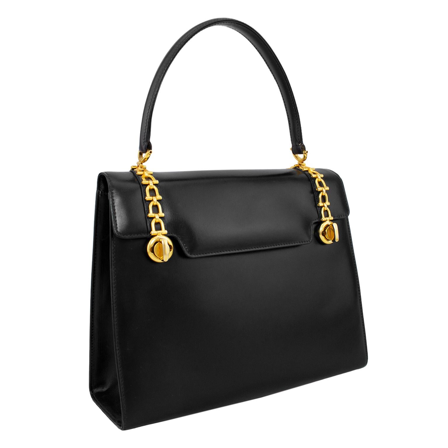 Stunning 1970's Gucci bag. A classic box shape with a single top handle and envelope style flap closure. The butter soft black leather is nicely contrasted by the gold tone metal horse bit details on flap. Bit detail trim ends with two twist locks