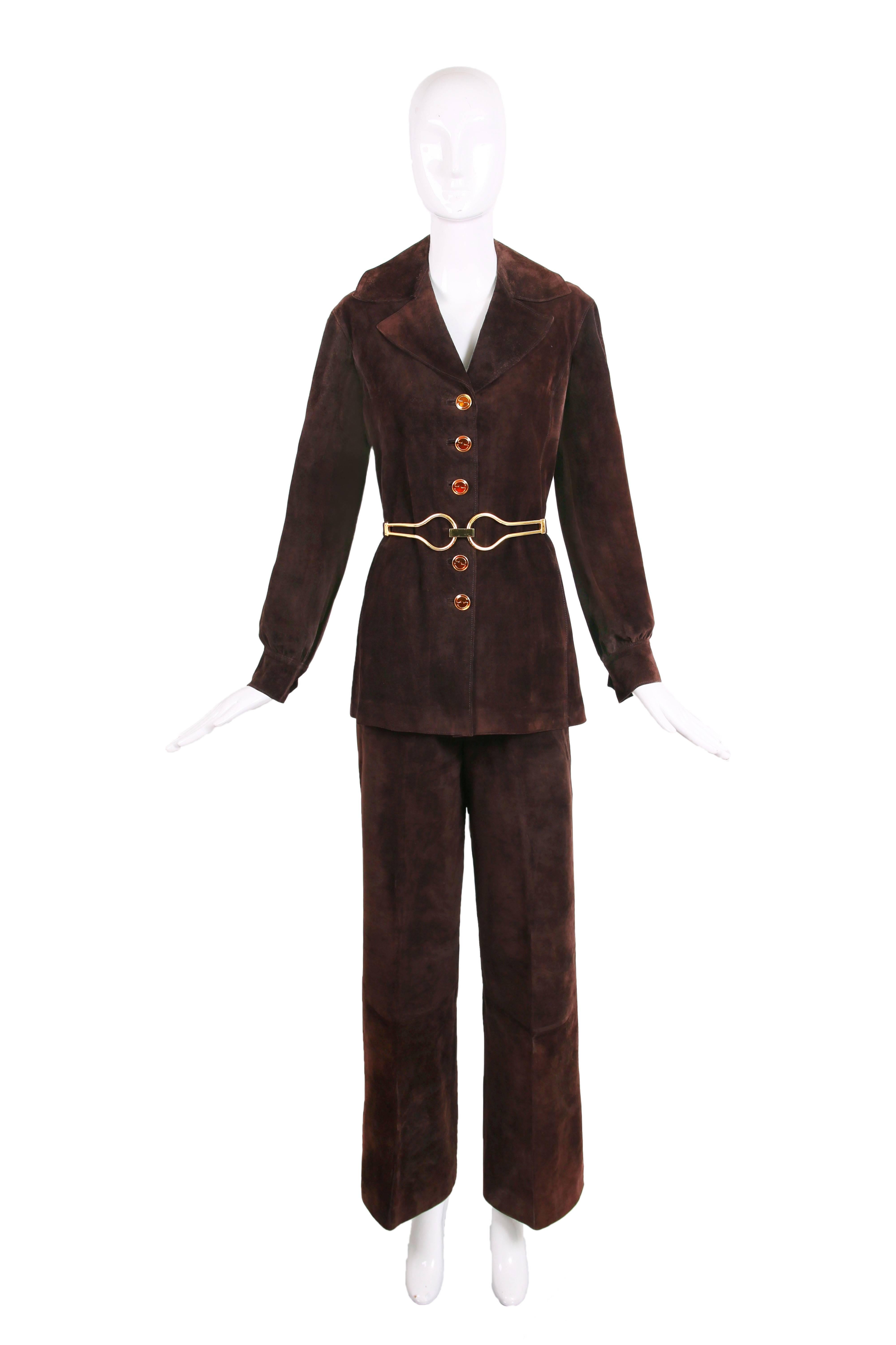 1970's Gucci brown suede jacket and pants ensemble with a detachable gold tone metal belt with a geometrically shaped buckle. Jacket features oversized GG logo glazed buttons down center front and is lined at the interior with Gucci logo fabric. In