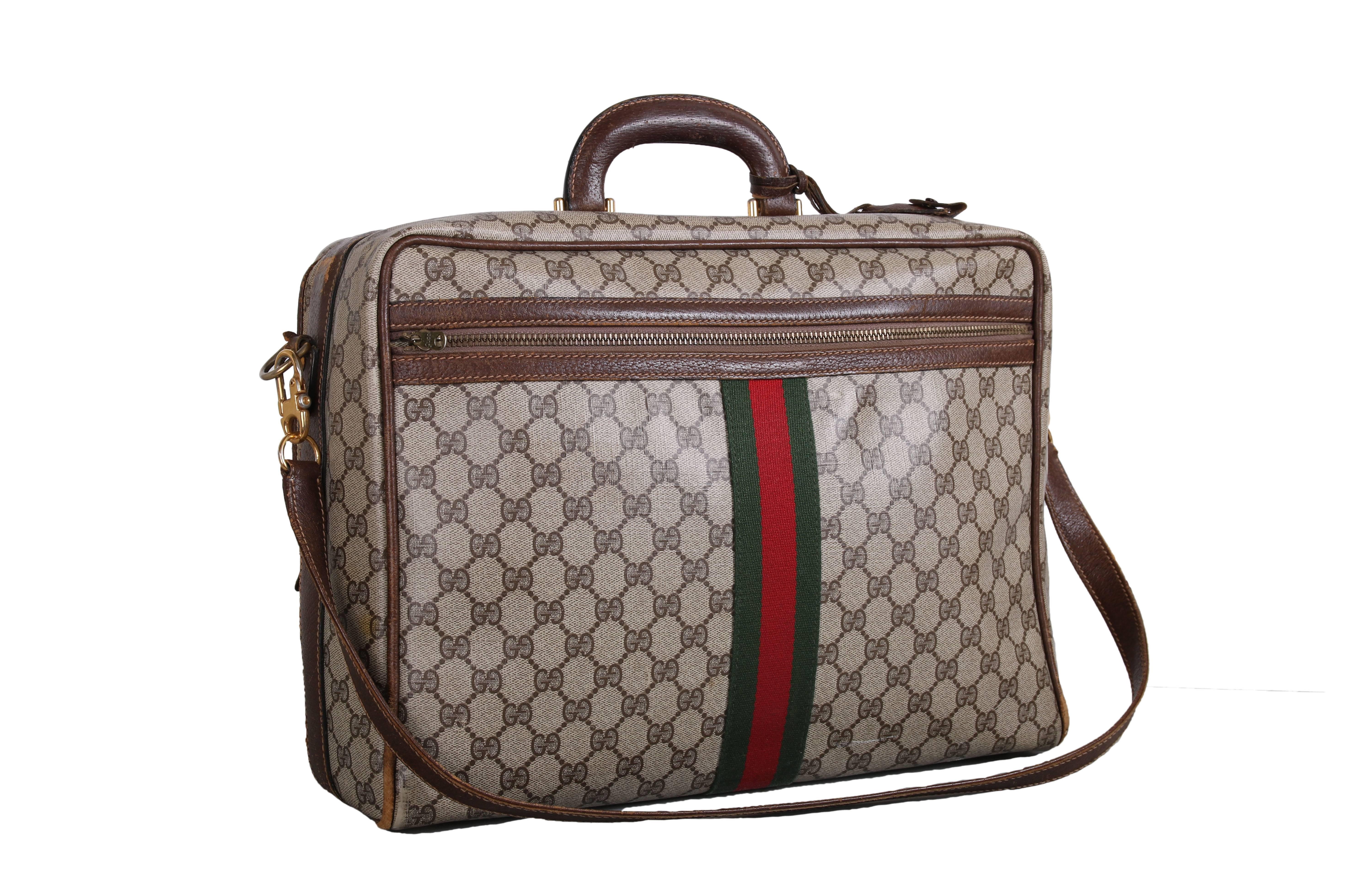1970's Gucci canvas travel or computer bag w/GG diamond web print, leather trim, green and red racer stripe down center front and back, a zippered compartment at front and back, detachable shoulder strap and leather top handle. Bag is in good