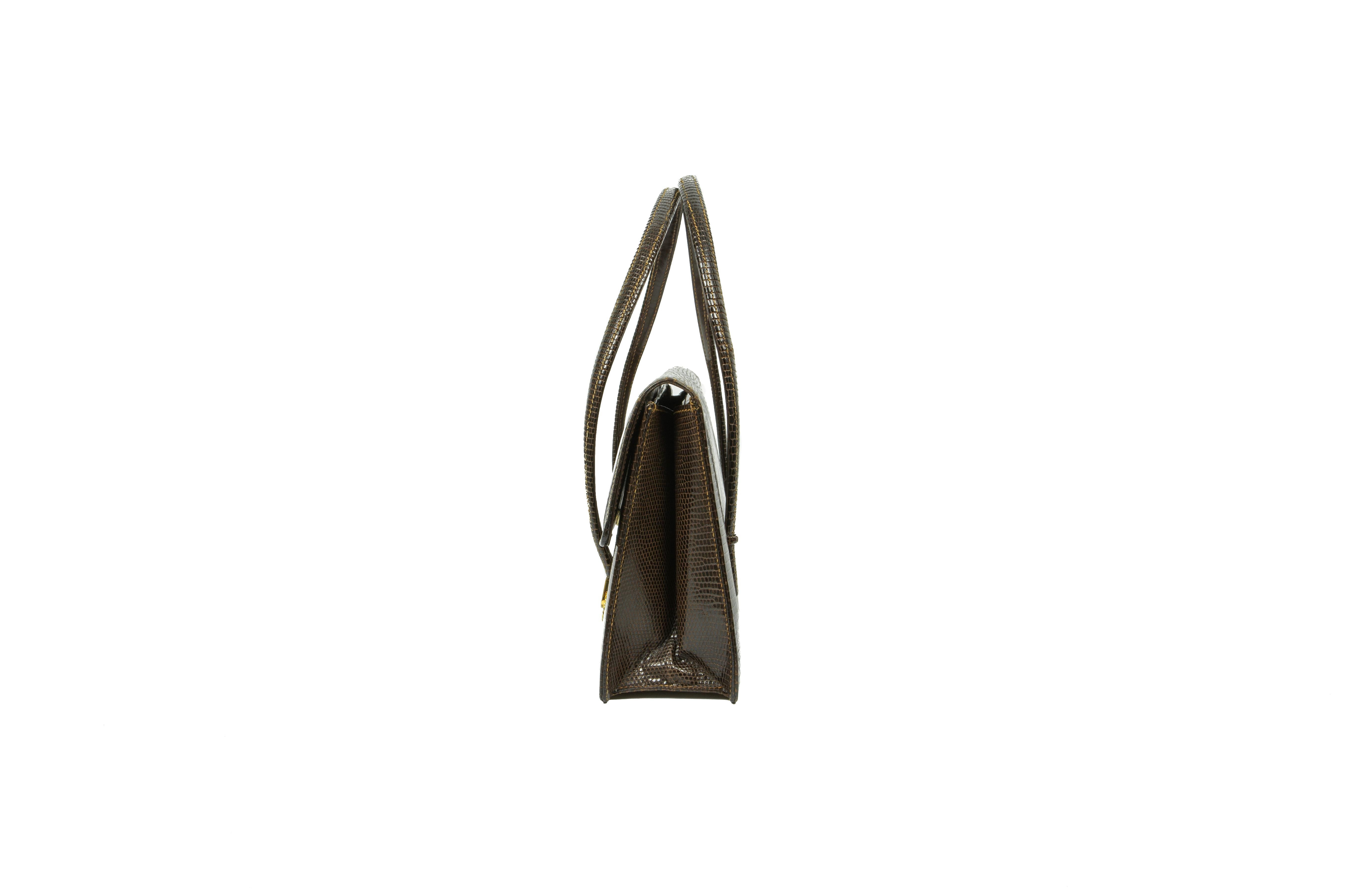 A late 1970s Gucci dark-sepia-brown lizard handbag, comprising of one gusseted compartment with one complementing zipper pocket incorporating a patch pocket and one further patch pocket, fully lined in beige leather, suspended on a pair of self flat