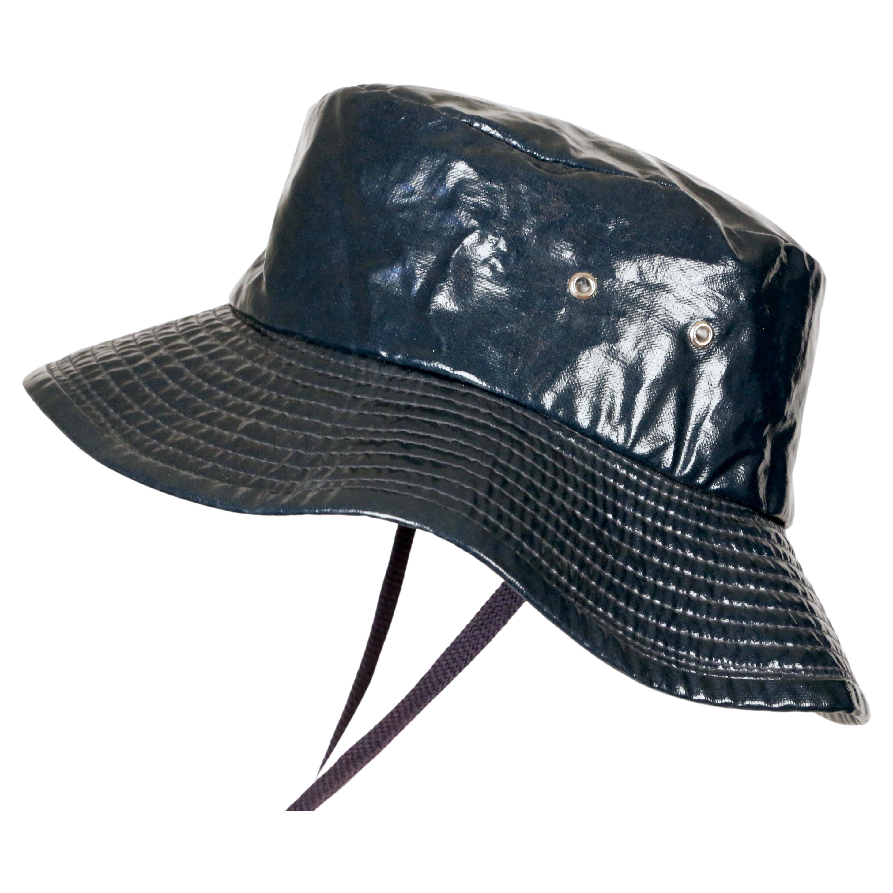 Dark petrol-blue waterproof bucket hat with stampede chin strap designed by Gucci dating to the 1970's. Labeled a Size 56 however this runs a little small and would best fit a 21.25