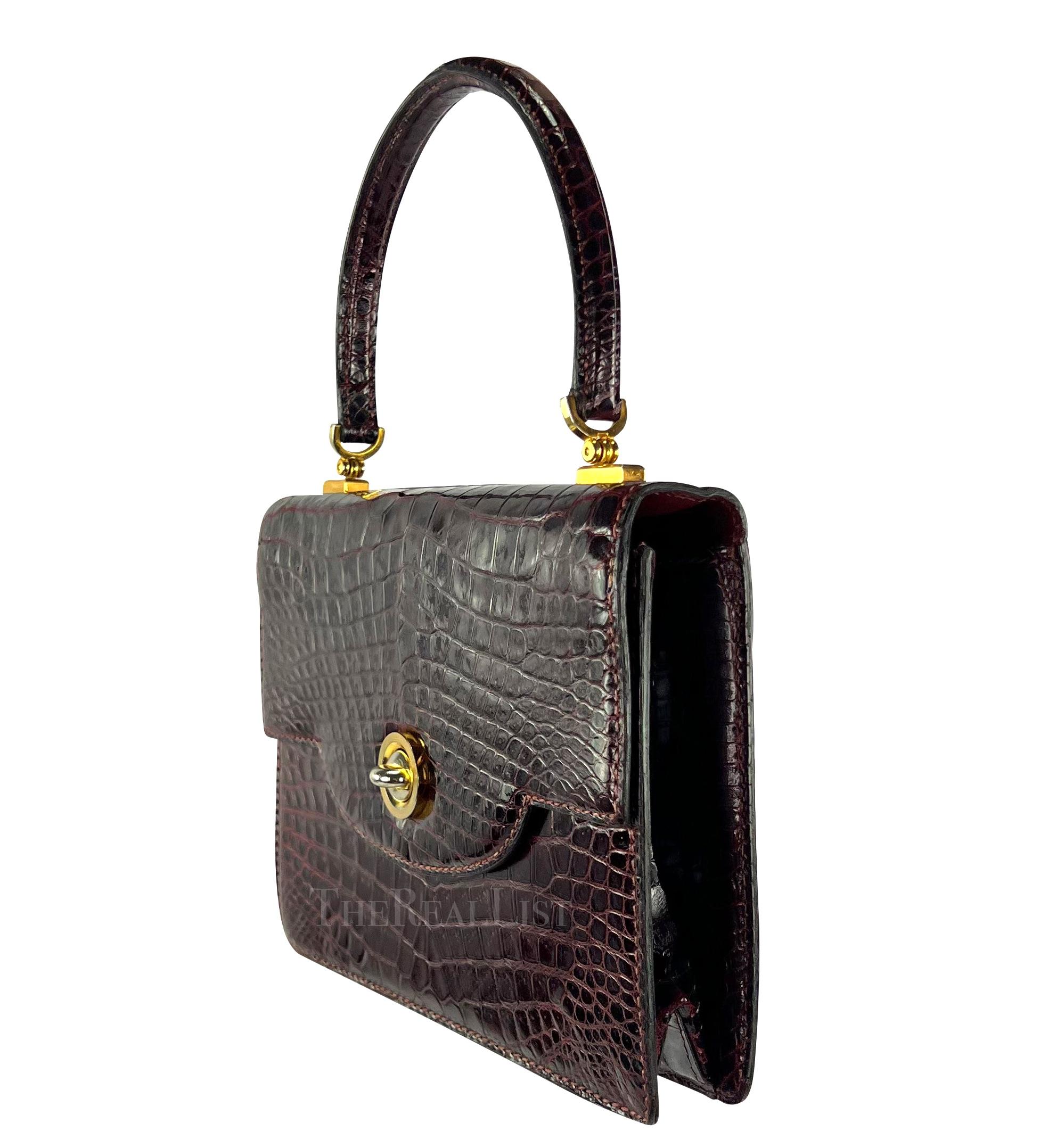 Presenting an incredible burgundy crocodile leather Gucci top handle flap bag. Dating back to the stylish 1970s, it epitomizes the essence of quiet luxury. Meticulously crafted from glossy burgundy crocodile and complemented by gold-tone hardware,