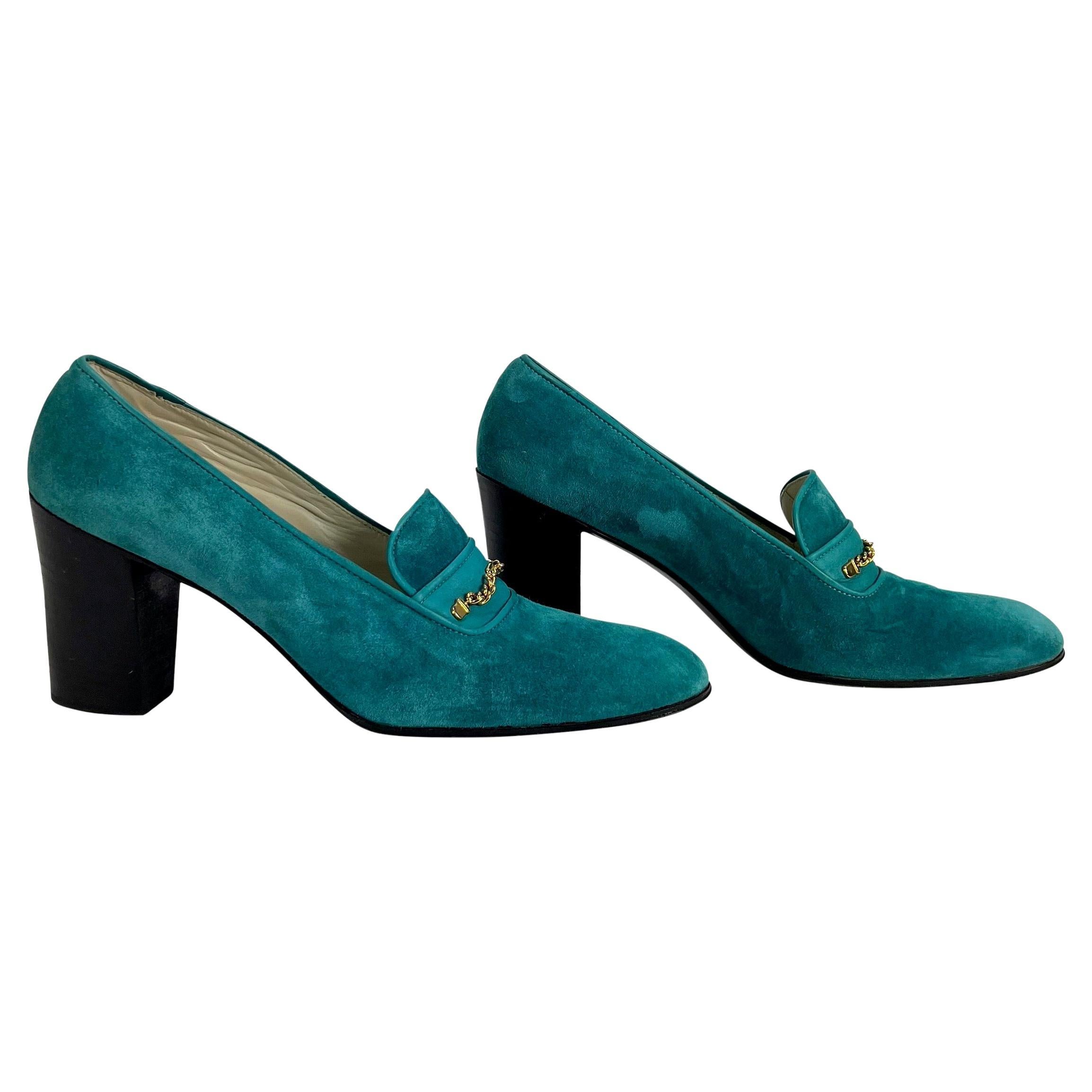 Presenting a fabulous pair of teal suede Gucci loafer heels. From the 1970s, this incredible pair of heels features a square toe and is complete with a gold chain detail with Gucci's 'GG' monogram centrally placed. Includes original Gucci shoe