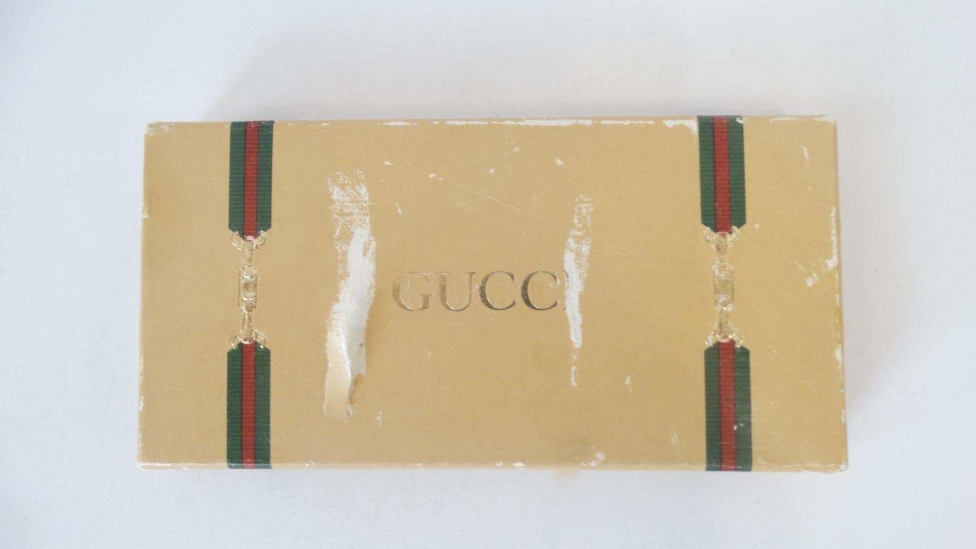 The Most Adorable Vintage Item Is Here! Circa 1970s, this mini Gucci perfume bottle features gold plated metal and beautiful navy blue enamel. The signature overlapping Gucci GG's are featured on the front and back of bottle. Removable lid stamped