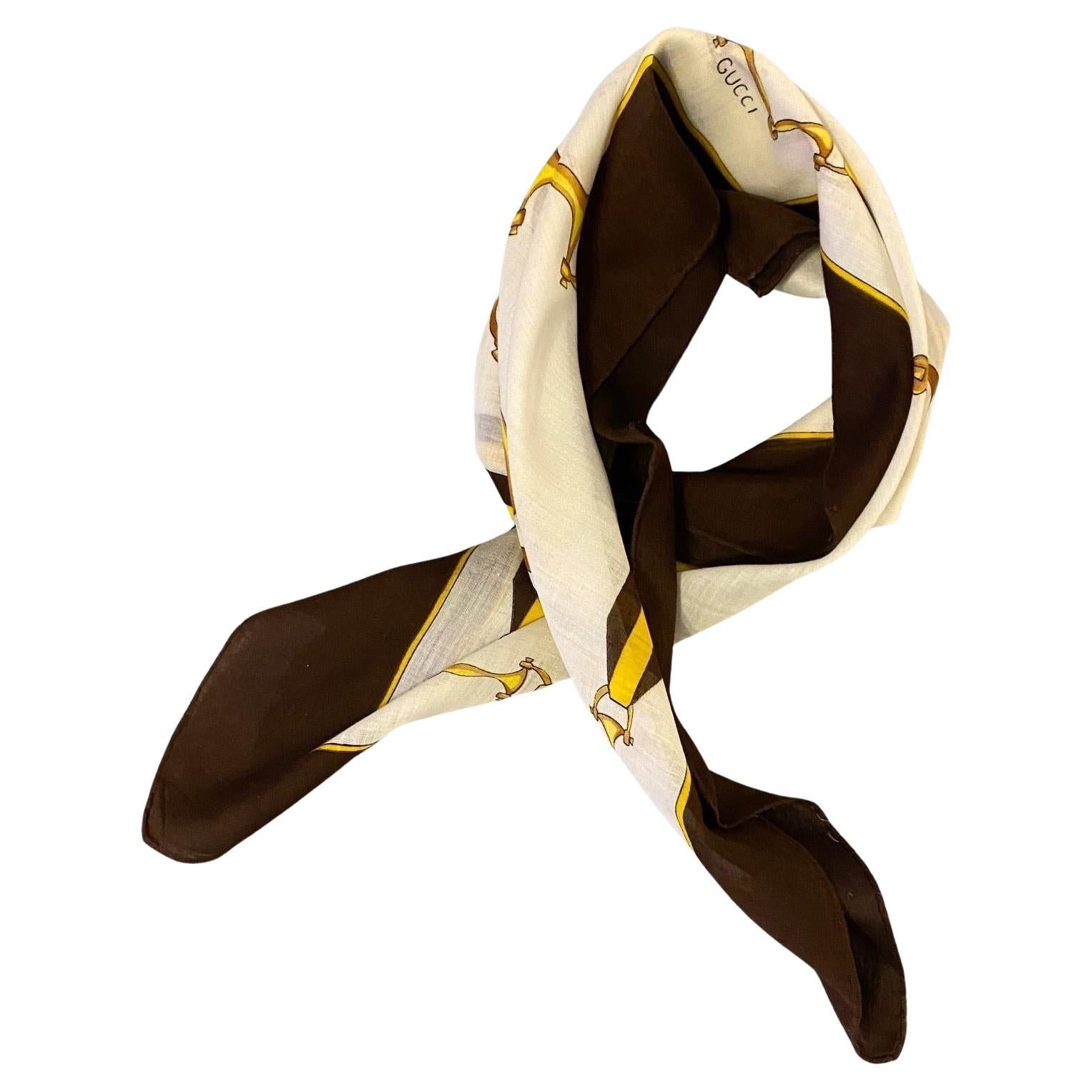 This traditional Gucci scarf features a signature horsebit print in gold, expertly hand-rolled edges, and is crafted from 100% cotton.
 
Condition: vintage, 1970s. Excellent condition
Measurements:  58x58cm cm