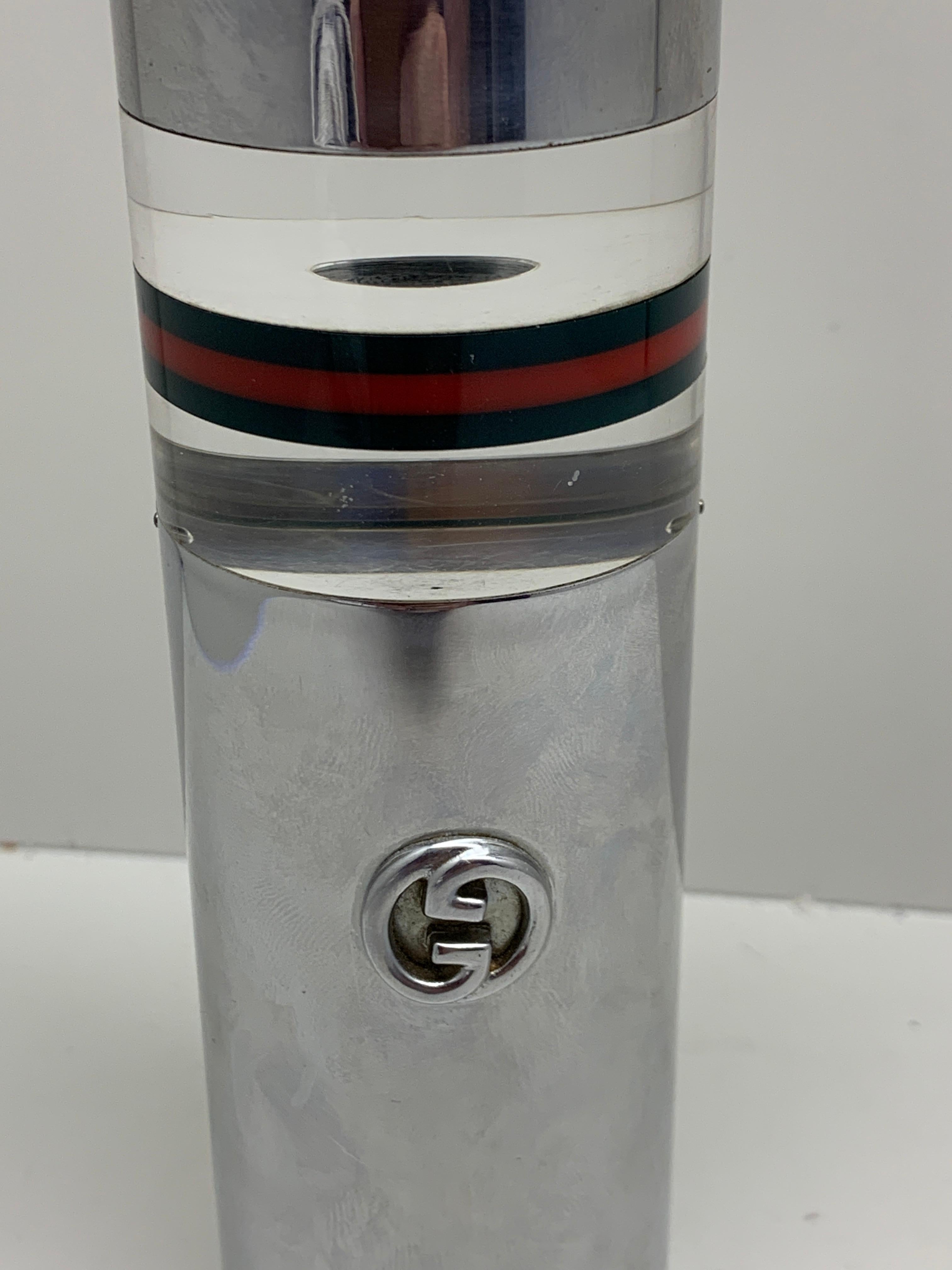 A vintage 1970s Gucci Italian table lighter in Lucite acrylic and metal chrome. It is signed Gucci on the base and has a clever hidden space for cigarettes or whatever you wish tucked away. It release with a twist and has a Lucite push rod. That is