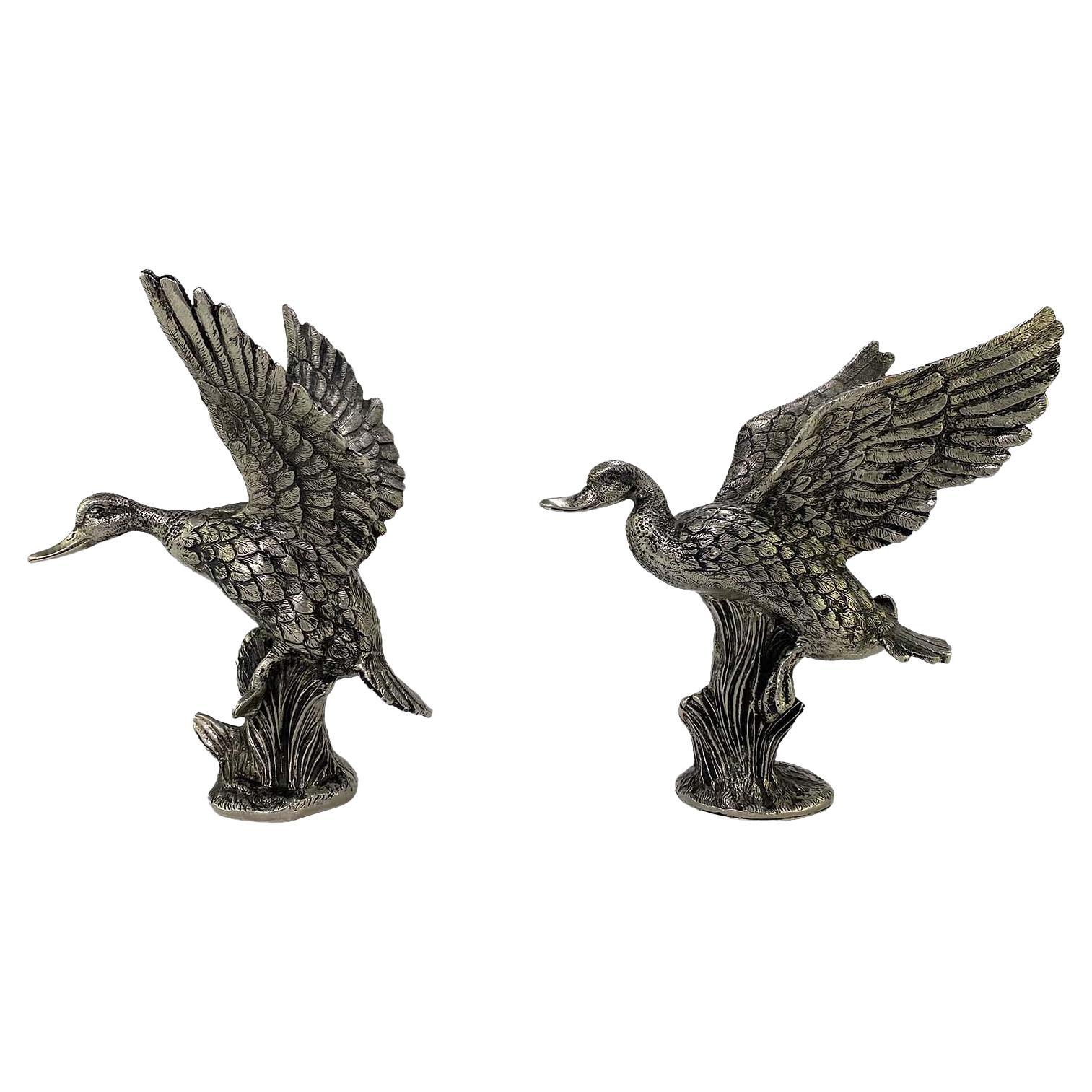 Presenting a set of silver mallard duck sculptures from the 1970s. The metal models take the country and equestrian influences of early Gucci and elevate them making them chic and shiny. These statues feature two different ducks taking flight in
