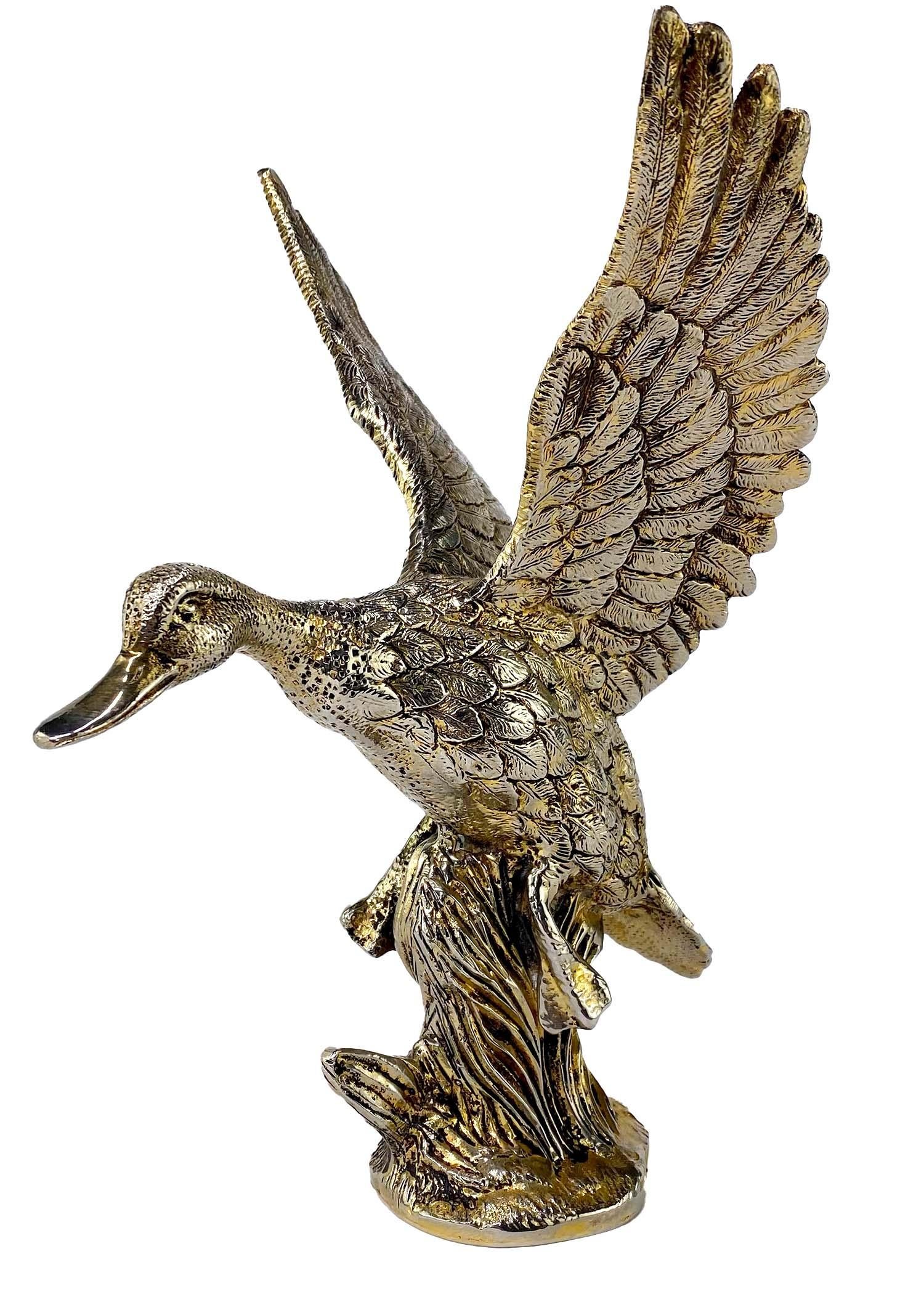 Presenting a gold-washed mallard duck sculpture from the 1970s. The metal model takes the country and equestrian influences of early Gucci and elevates them making them chic and shiny. This statue features a duck taking flight in grass. The