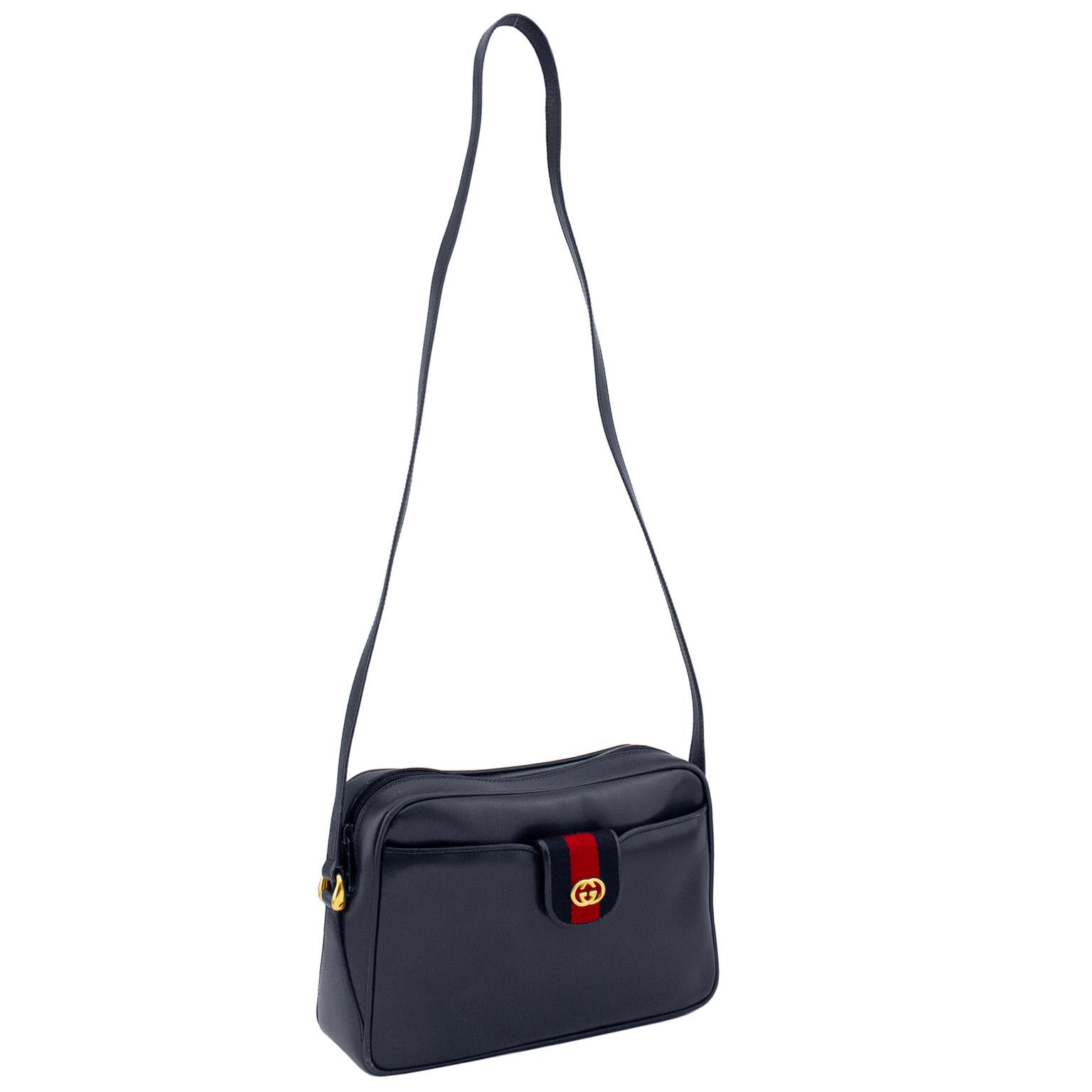 Classic and elegant 1970's Gucci navy box leather camera style shoulder bag. Red and navy webbed stripe front clasp reveals a separate zip top wallet when unsnapped and removed from the front pouch. Its like a bonus wallet. In immaculate condition