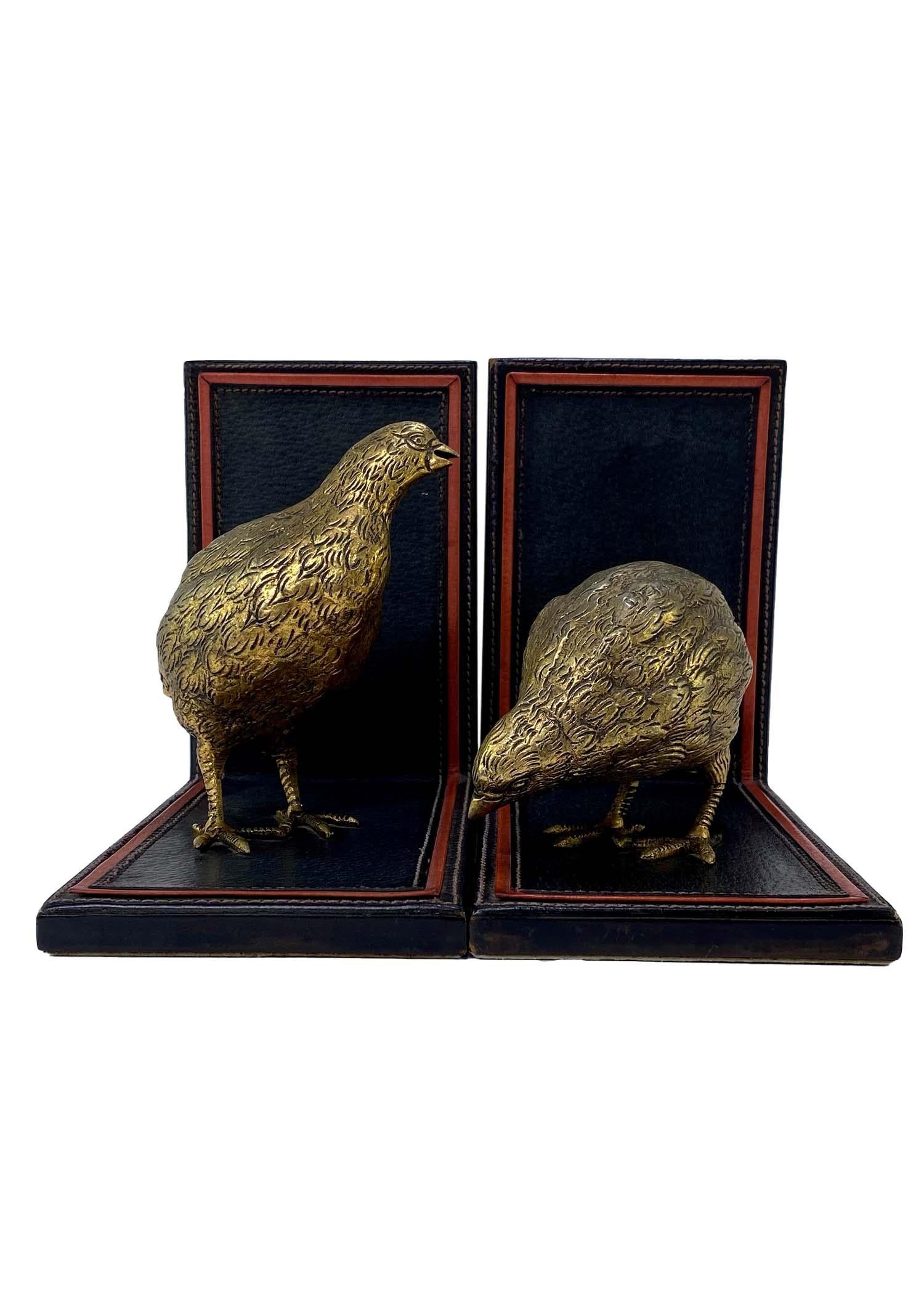 TheRealList presents: a set of gold quail figures on leather bookends, designed by Gucci. The metal models elevate the country and equestrian influences of early Gucci, making them chic and shiny. These bookends feature two quail figures in