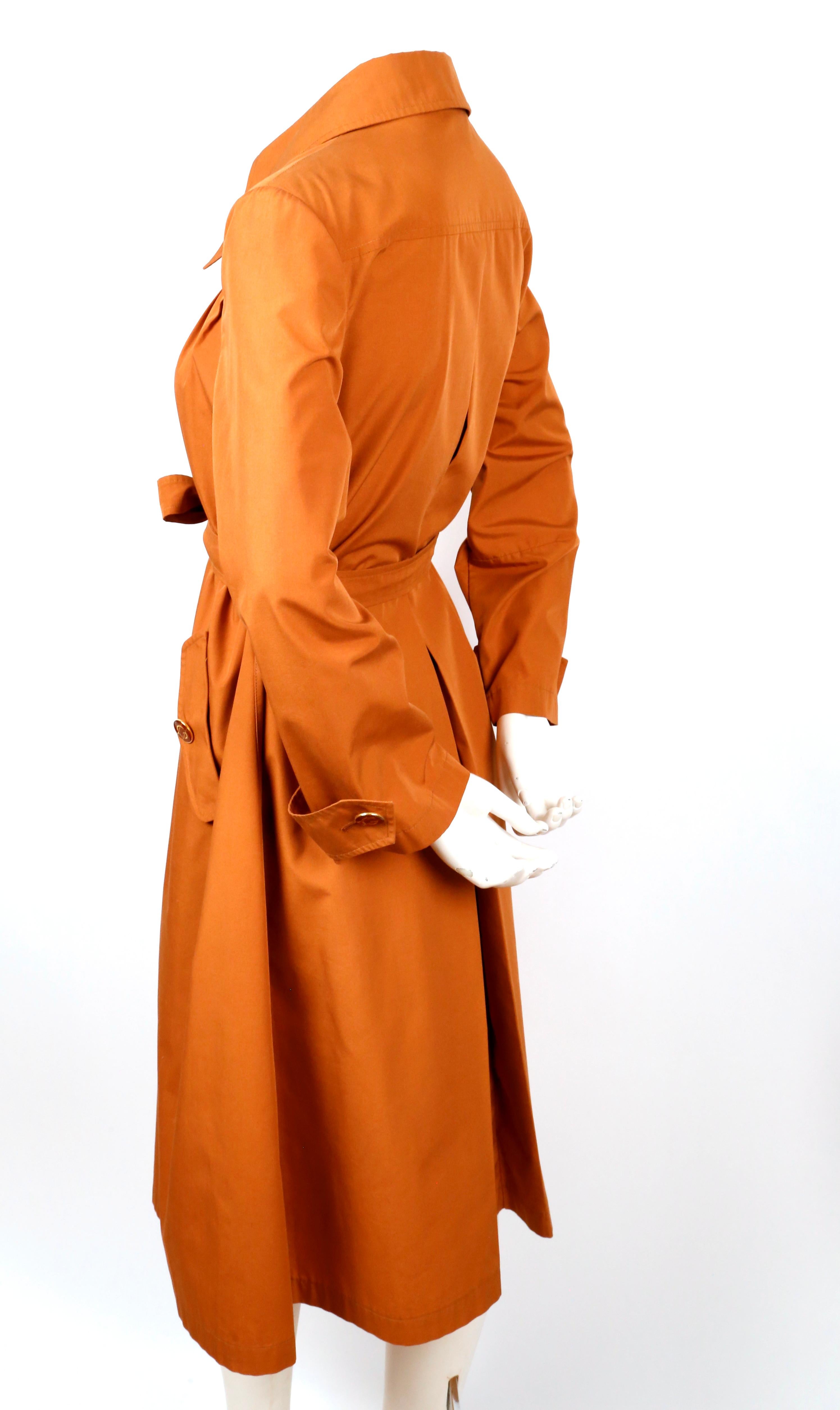 Very rare, rust colored trench coat with enameled GG buttons designed by Gucci dating to the 1970's. Labeled an Italian 46, however this best fits a US 2-6. Approximate measurements: shoulder 15