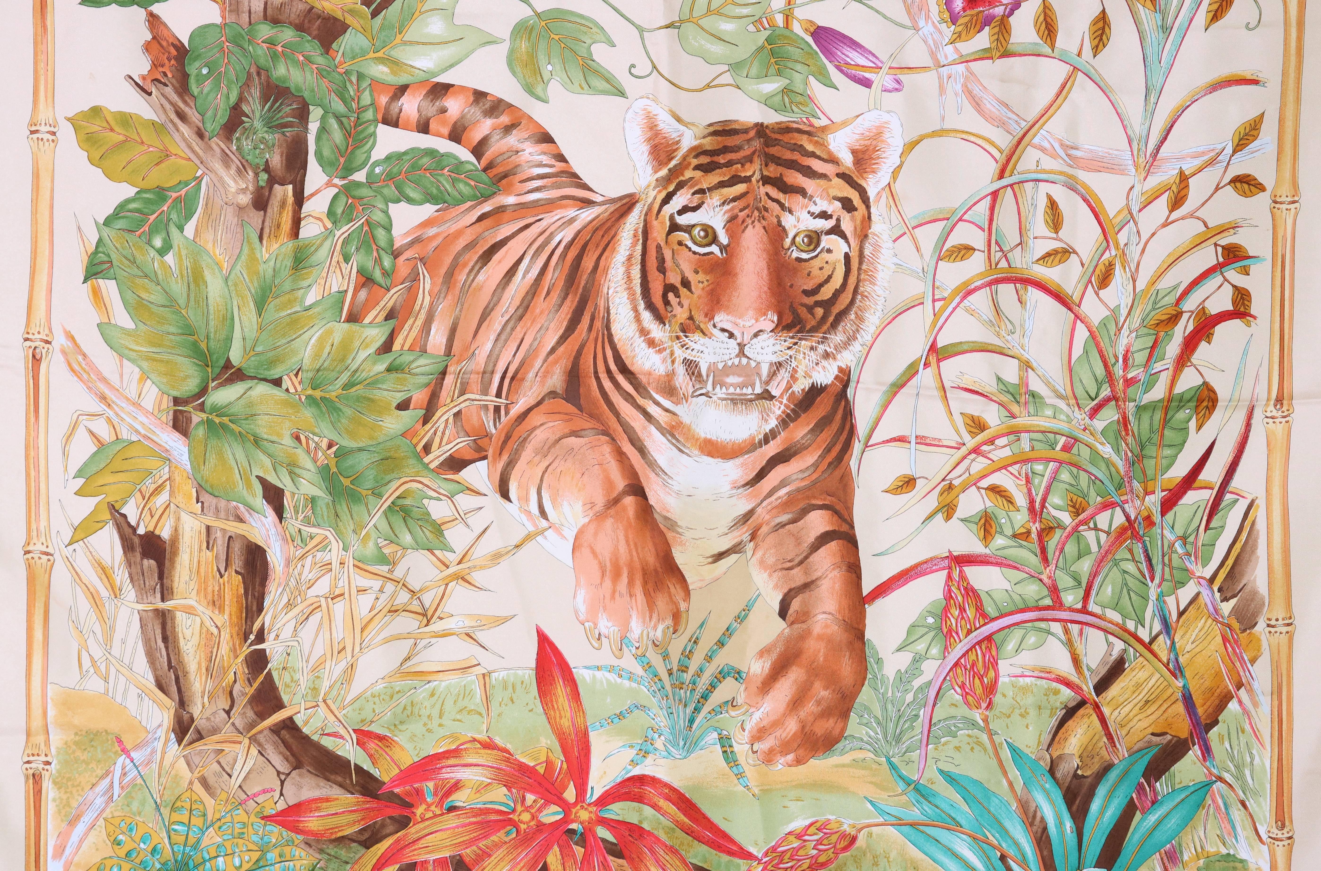 1970's Gucci silk scarf w/a tiger in the jungle framed by a bamboo border. Gucci logo in upper left and lower right corner. In very good condition with a tiny light pink mark at one corner. Labeled 