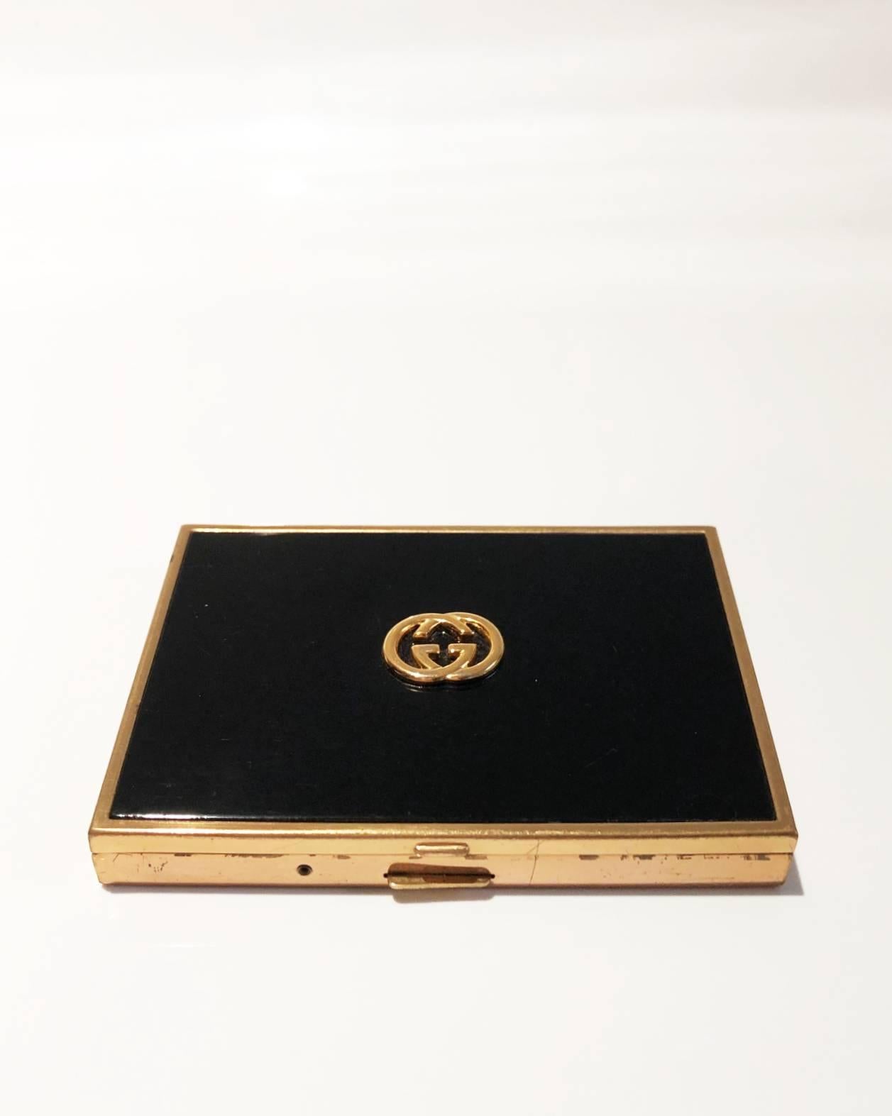 Timeless elegance from Gucci. This is a compact cigarette case / smoking box perfect for cocktail occasions. It features black varnished top with GG logo gold metal ware,  black enamel colour and has the Gucci logo on the top and inside has the name