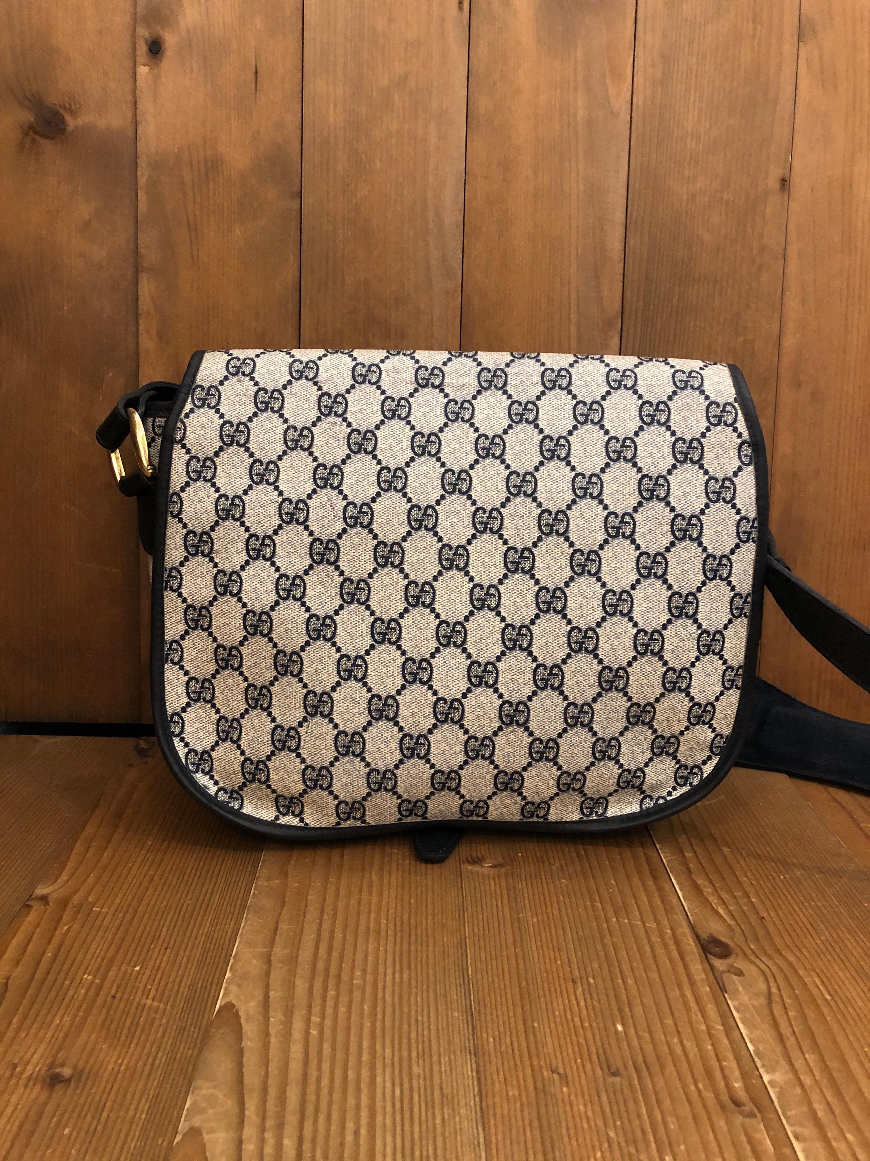 Borsa Gucci vintage in tela Monogram degli anni '70 con l'iconico morsetto Gucci collegato da un nastro rosso/marino. Foderato con tessuto con diamanti di Gucci. L'interno presenta uno scomparto principale, una tasca interna con zip, una tasca con