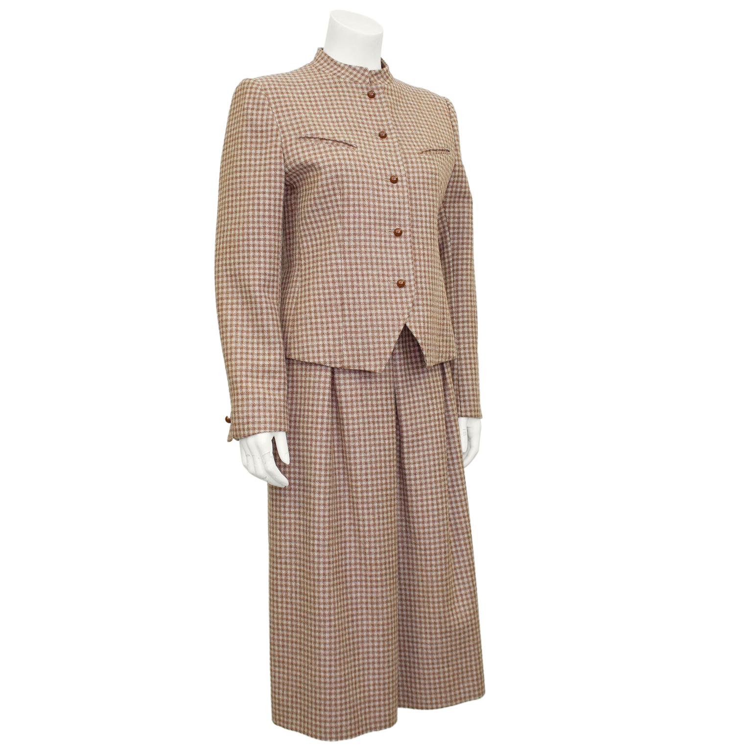 Lovely Guy Laroche Diffusion skirt suit from the 1970’s. Brown and beige wool plaid with chocolate brown plastic dome buttons. Collarless with diagonal slit pockets and darts at bust and small triangular cutout at hem. Skirt is high waisted a-line