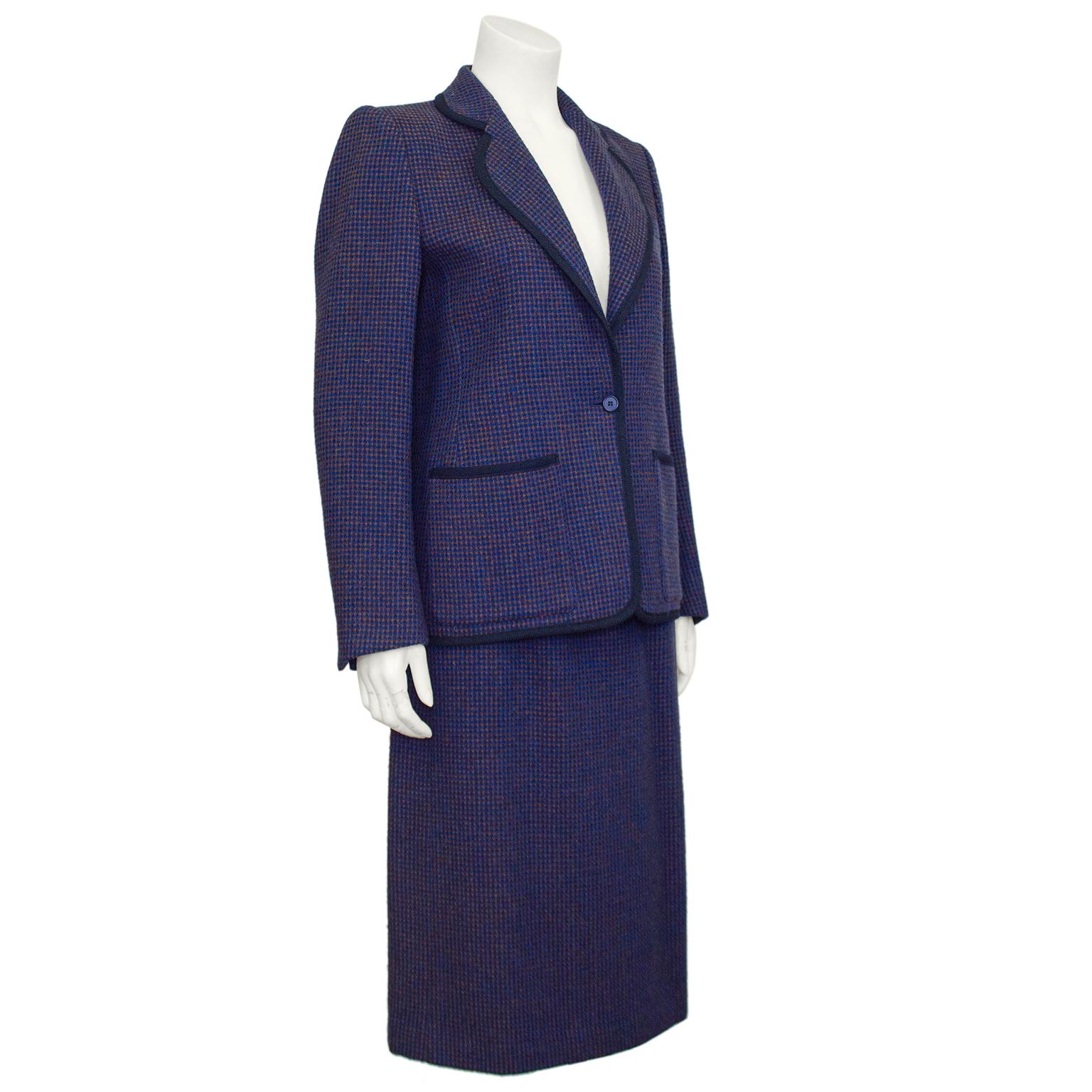 Lovely Guy Laroche purple tweed skirt suit from the 1970s. Blazer features long sleeves, a rounded notched collar, single button closure and two patch pockets at hips. Collar and pockets have a contrasting black woven trim. Skirt is classic high