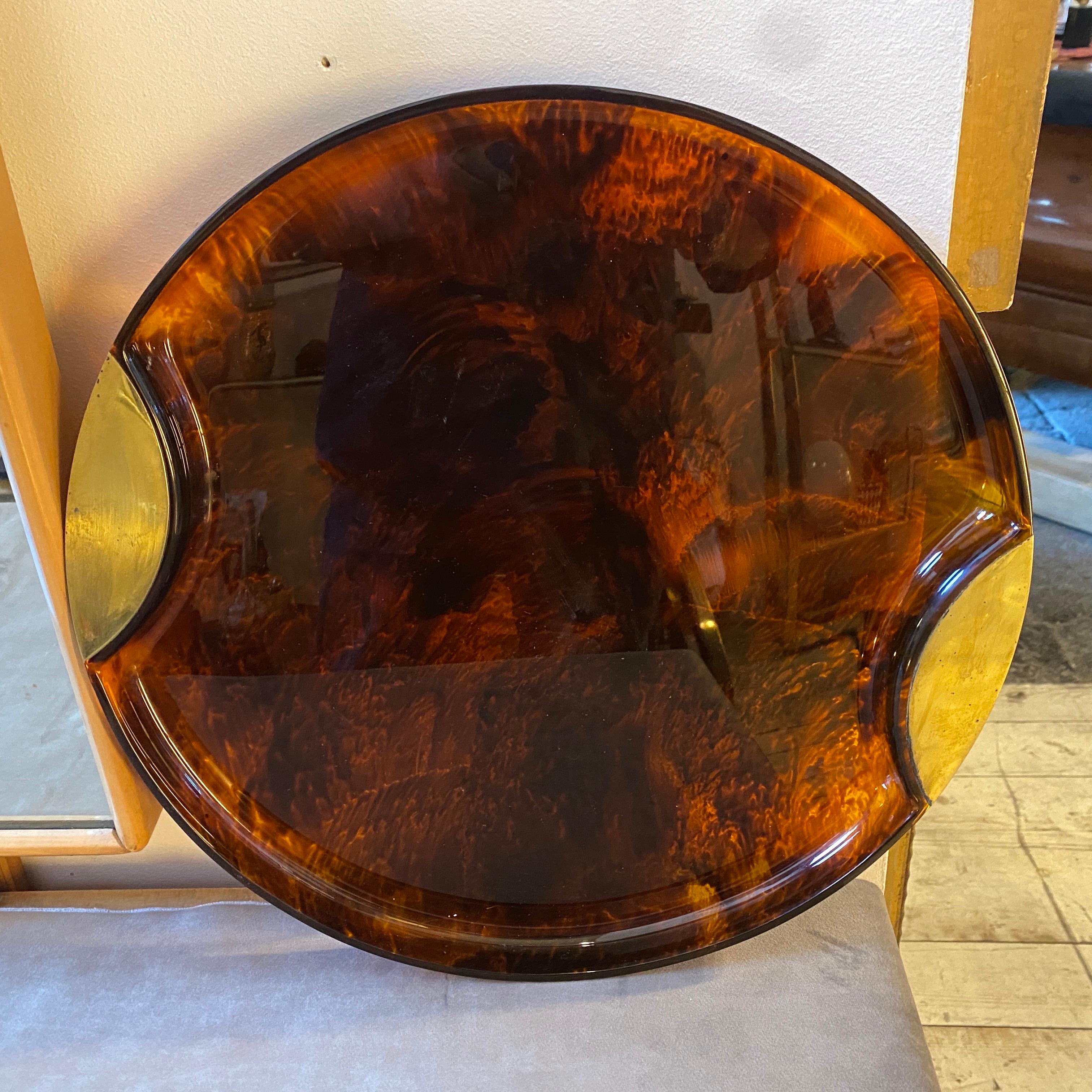 An iconic lucite tray made in Italy in the Seventies by Guzzini, it's in very good conditions, brass in original patina. It can be used as a centerpiece or as a serving tray.